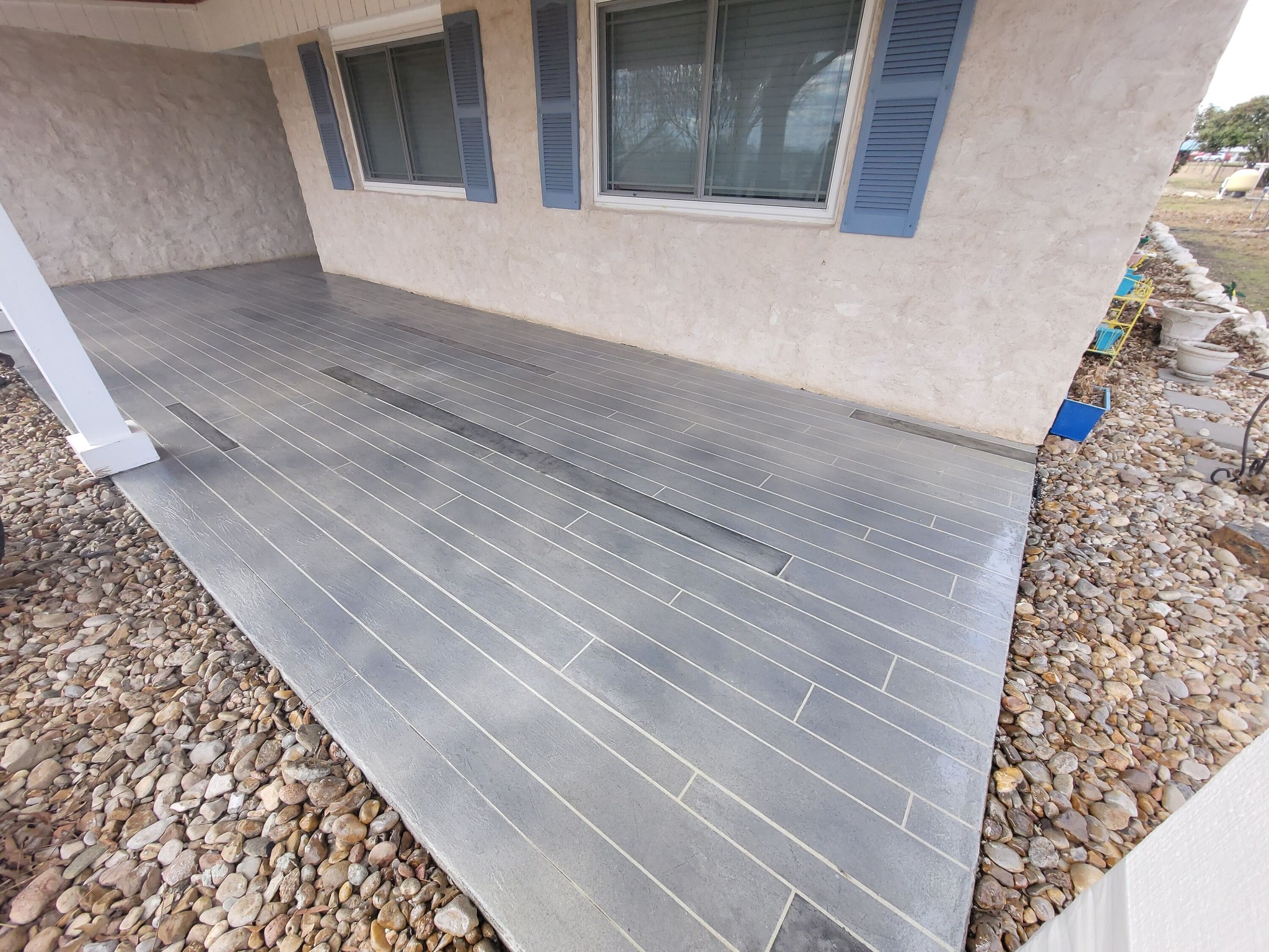 Concrete patio floor outside a freshly remodeled home home