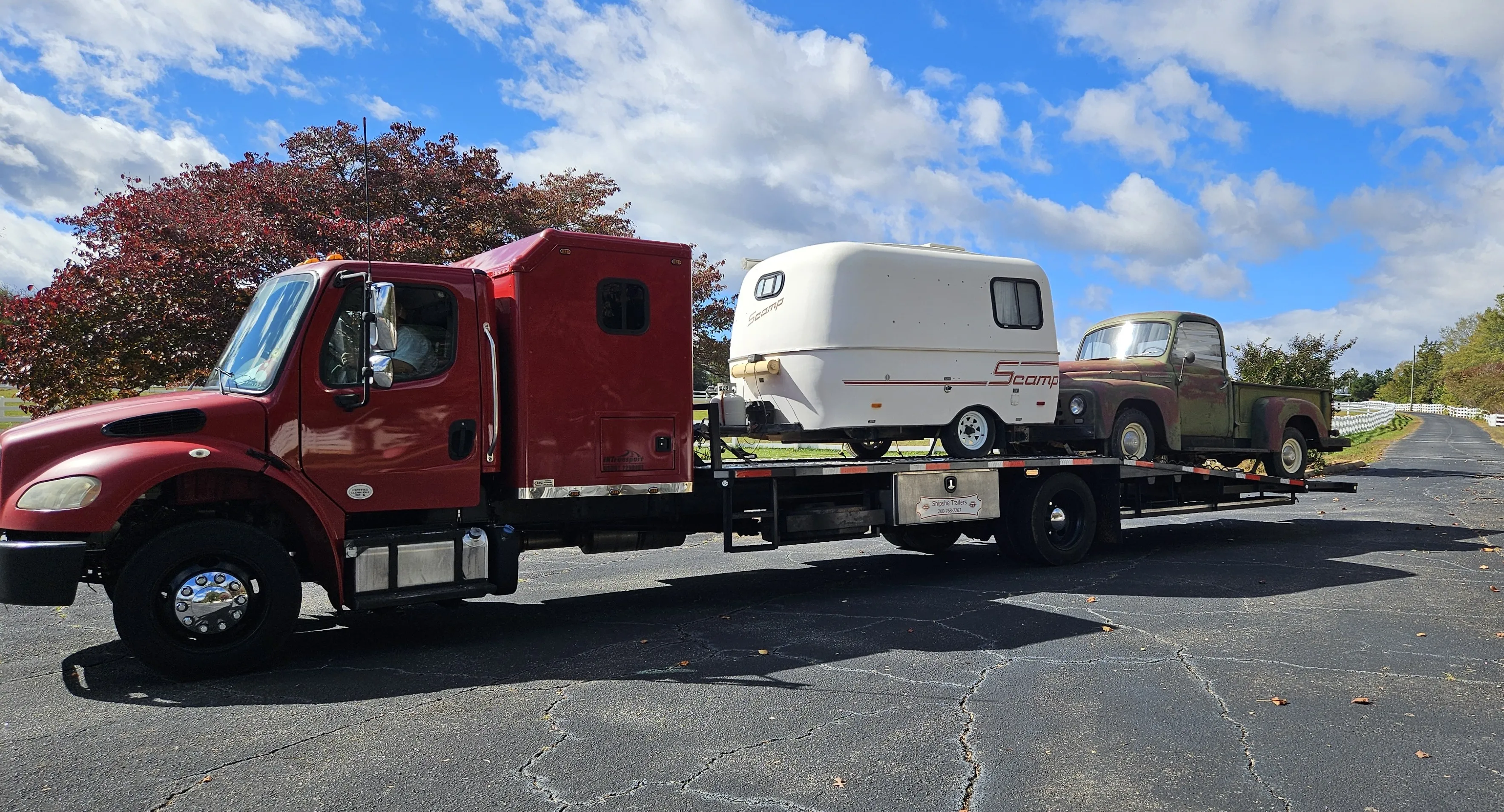 Freightliner M2 hauling a Scamp travel trailer and a vintage International pickup on a flatbed trailer