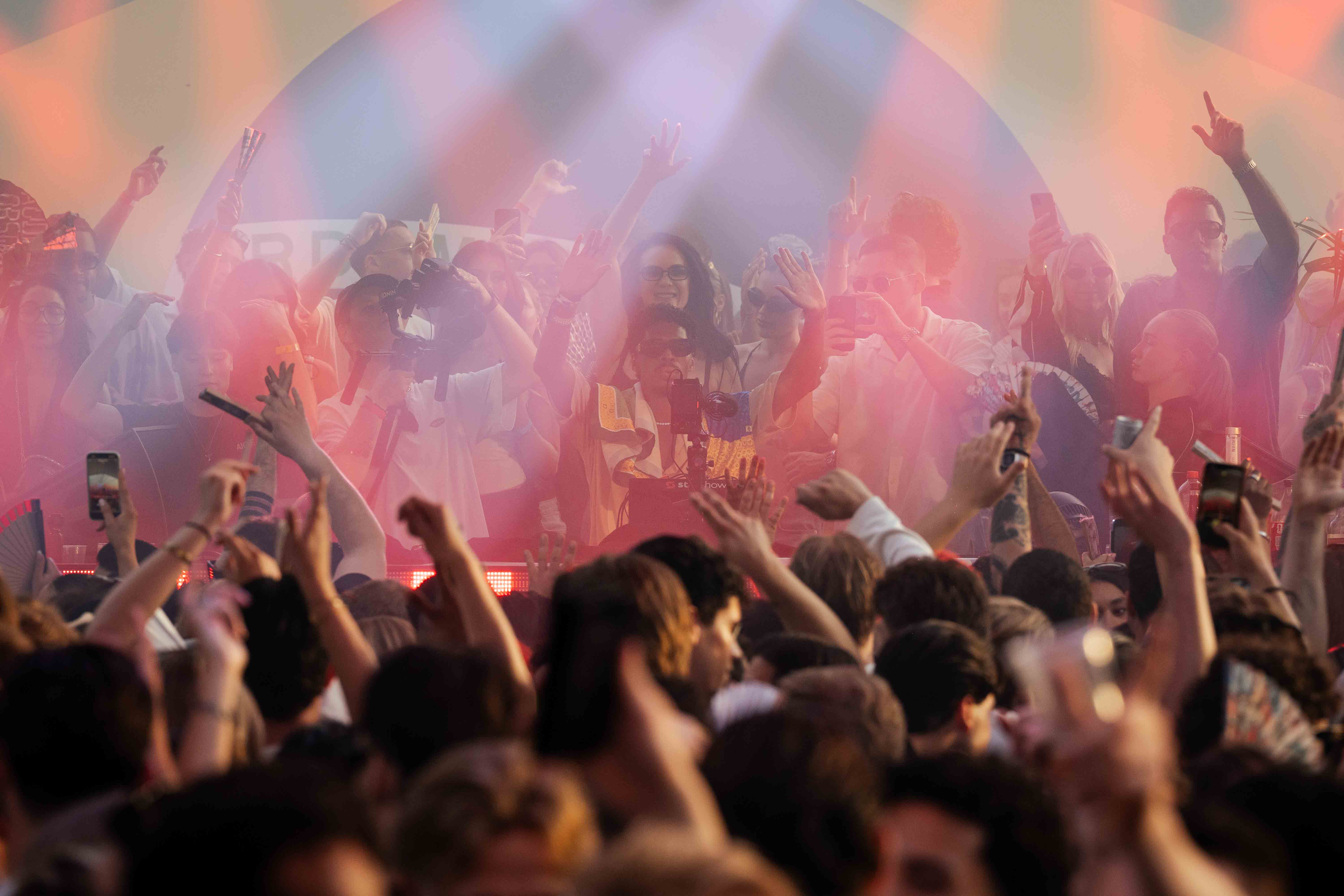 Crowd in roze lichtwaaier, lichtontwerp door Starshow, DJ Menesix in het midden