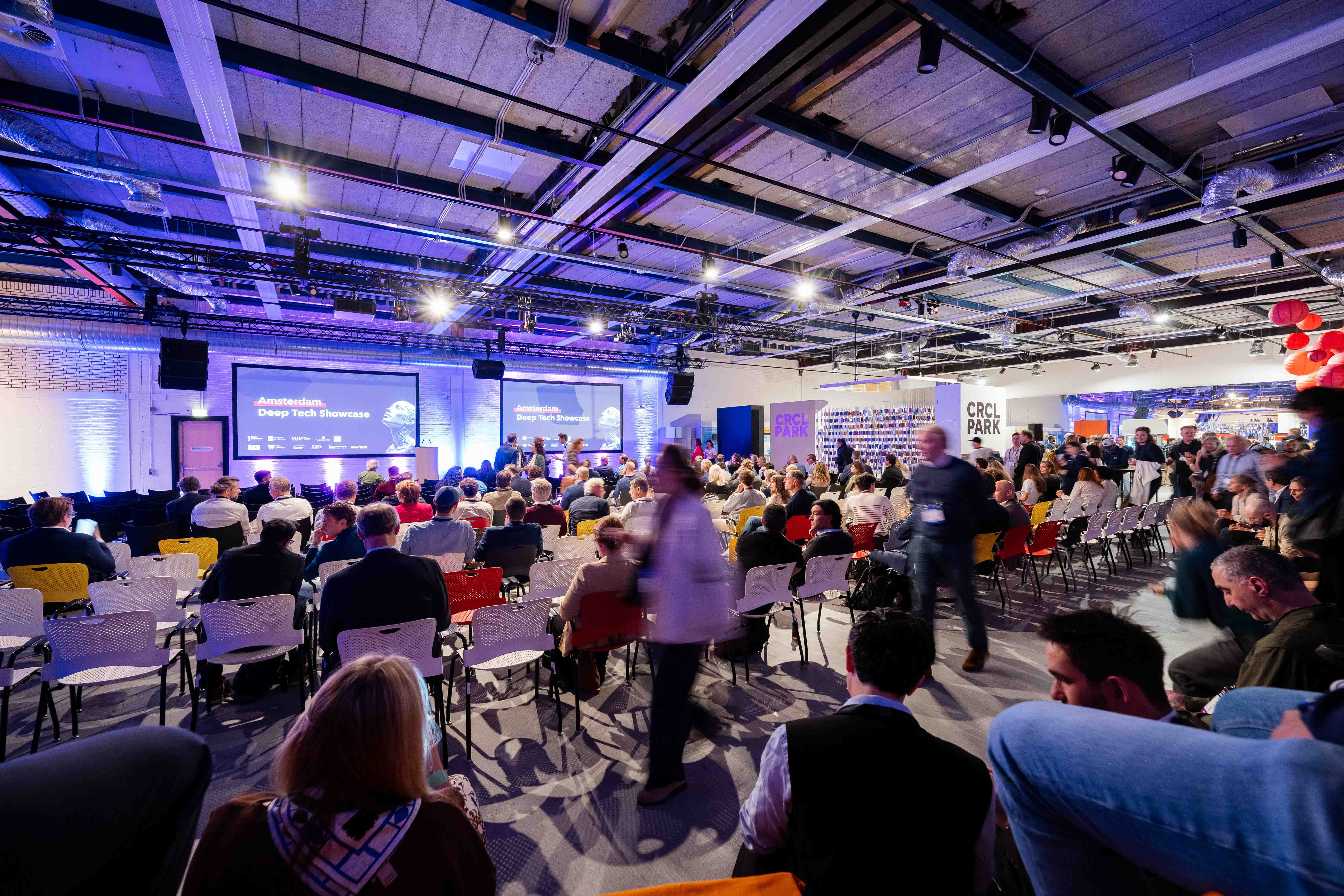 Publiek in de zaal met ledschermen op de achtergrond tijdens de Amsterdam Deep Tech Showcase