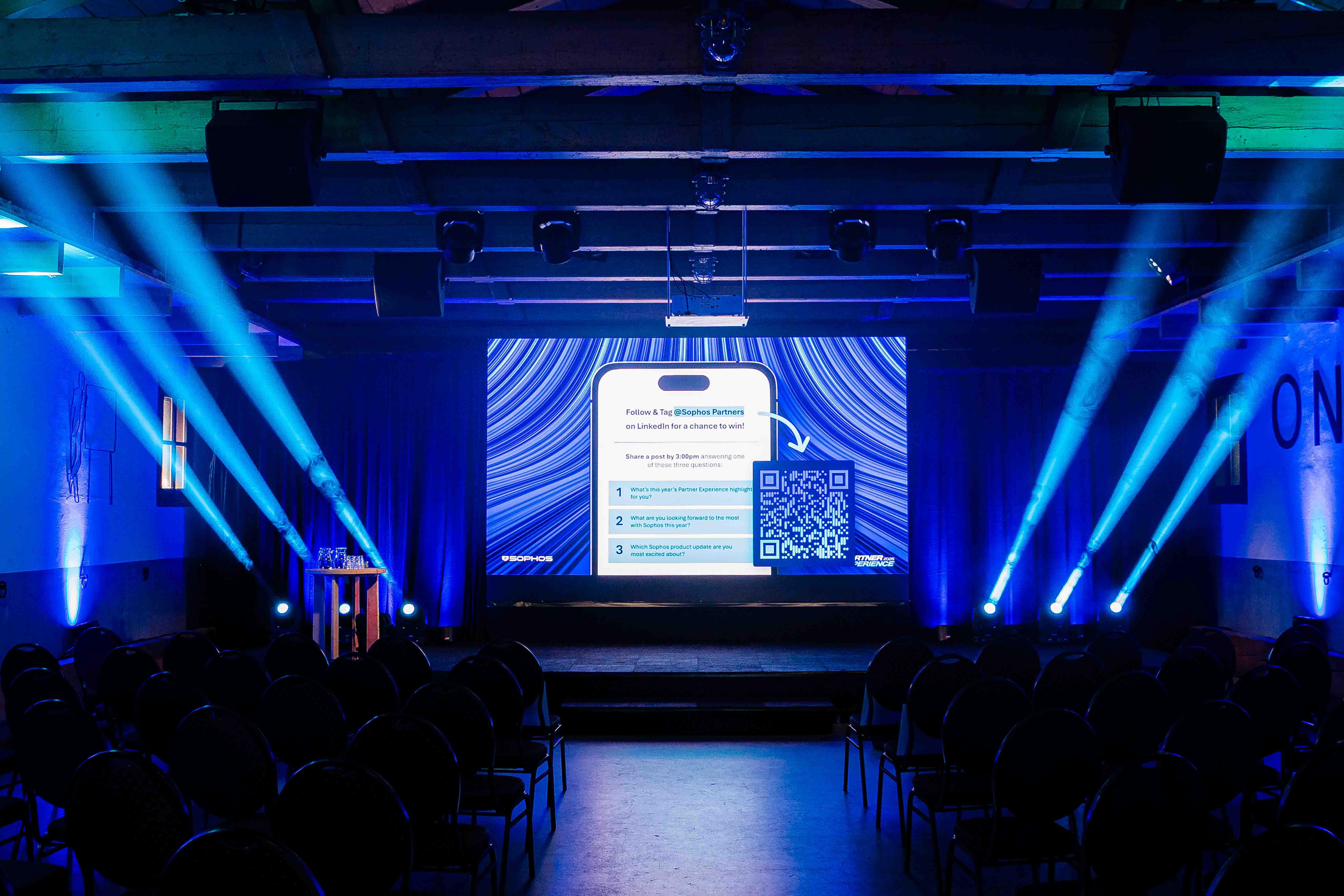 Podium met sfeervolle rook en lichteffecten tijdens de Sophos Partner Experience in Fort Wierickerschans