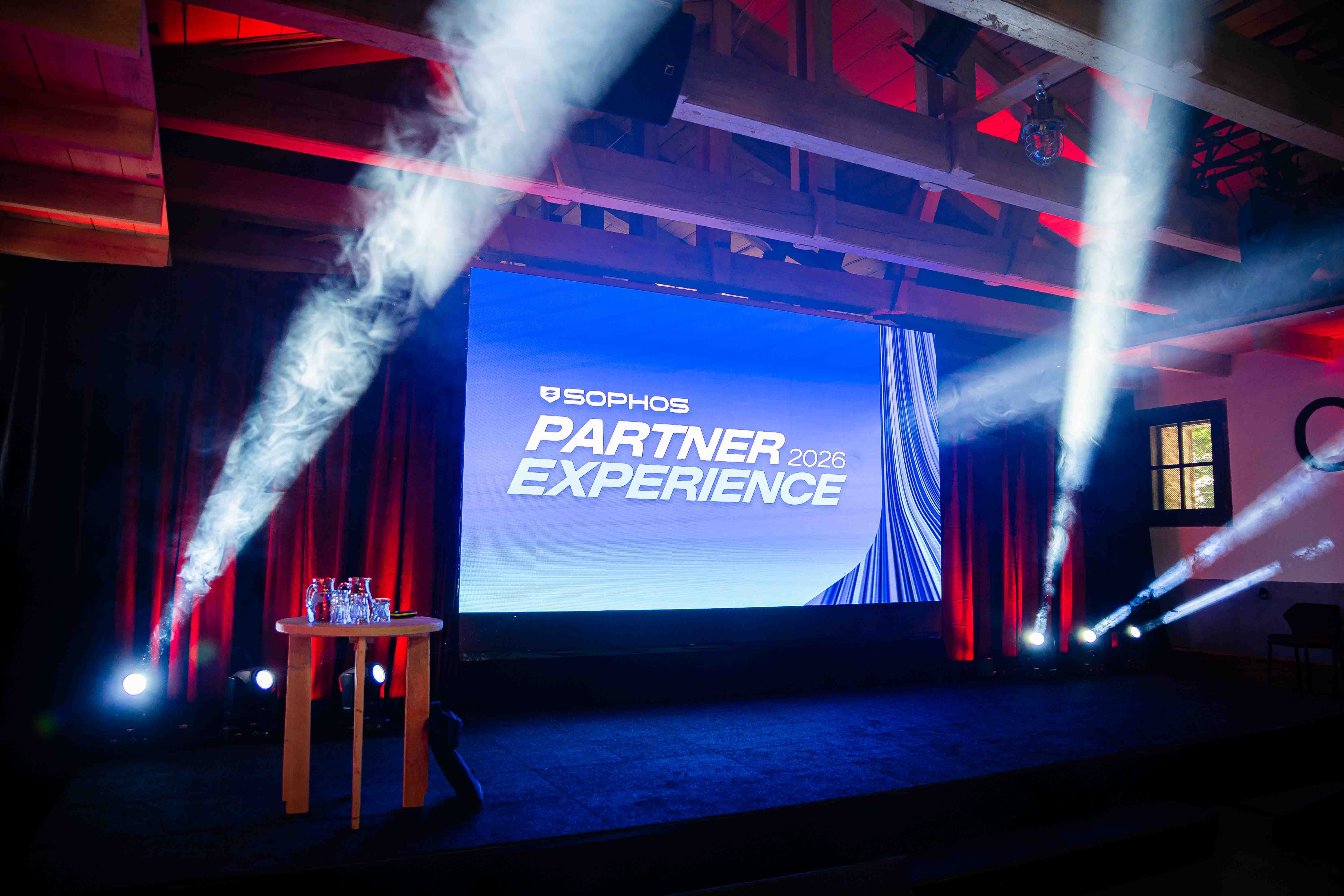 Podium met sfeervolle rook en lichteffecten tijdens de Sophos Partner Experience in Fort Wierickerschans