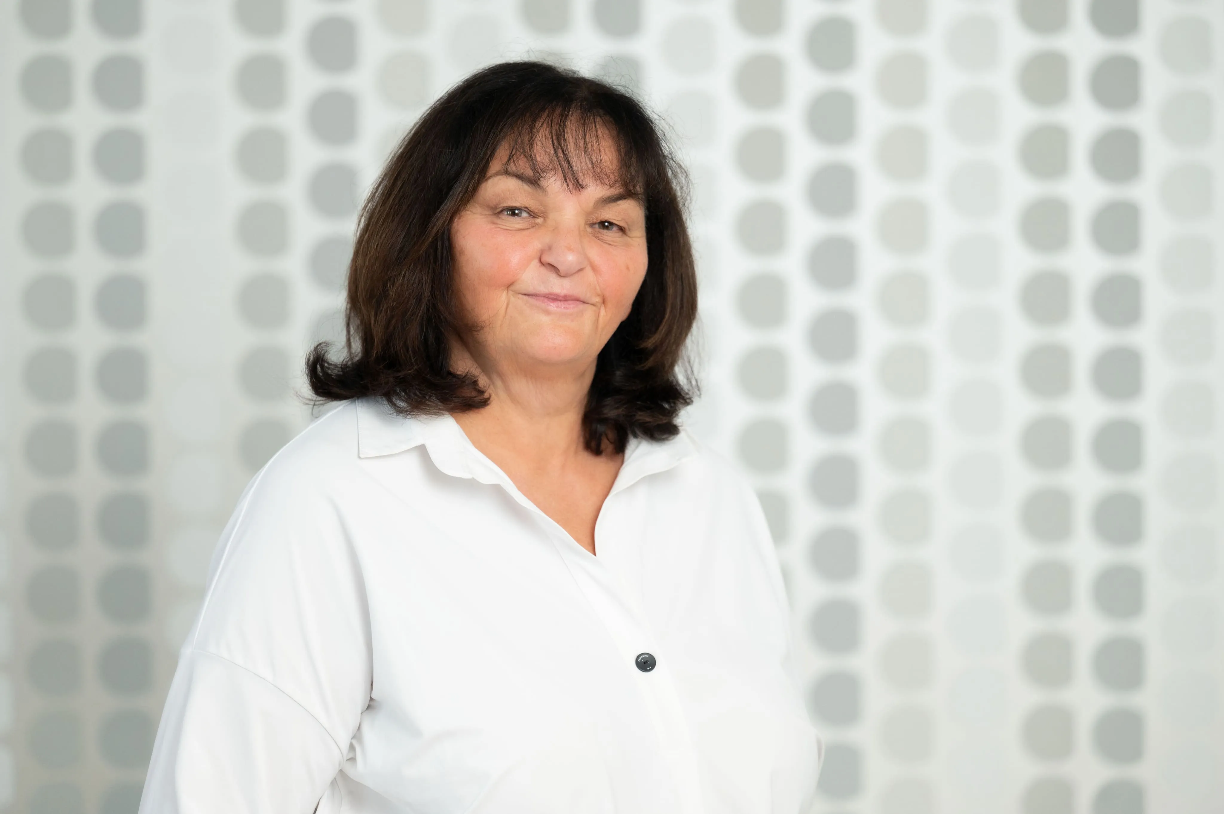 Mitarbeiterporträt einer Frau von Ingenieurbüro Bittner vor gemustertem Hintergrund