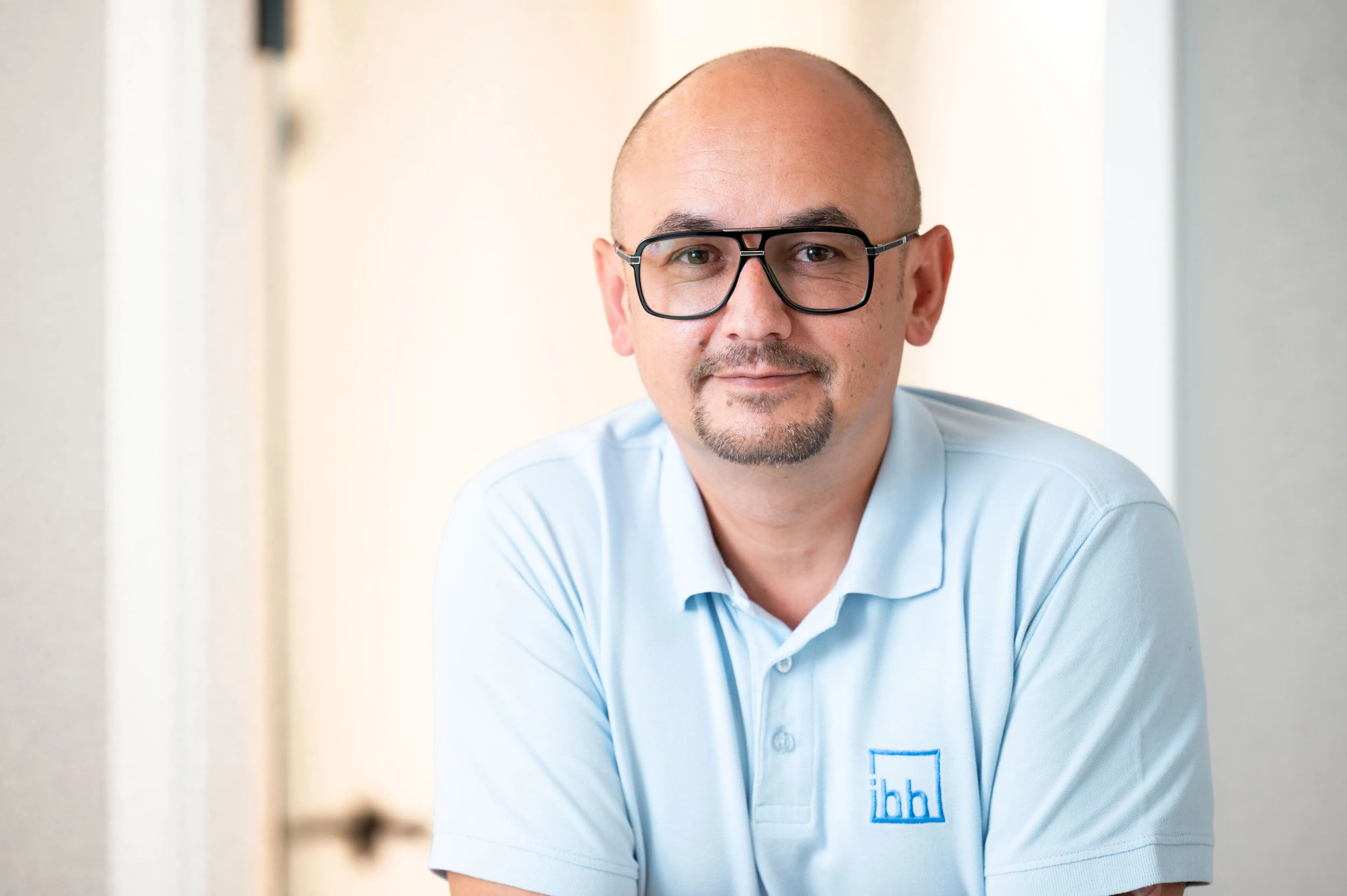 Mitarbeiterporträt eines Mitarbeiters mit Brille von Ingenieurbüro Bittner im Büro