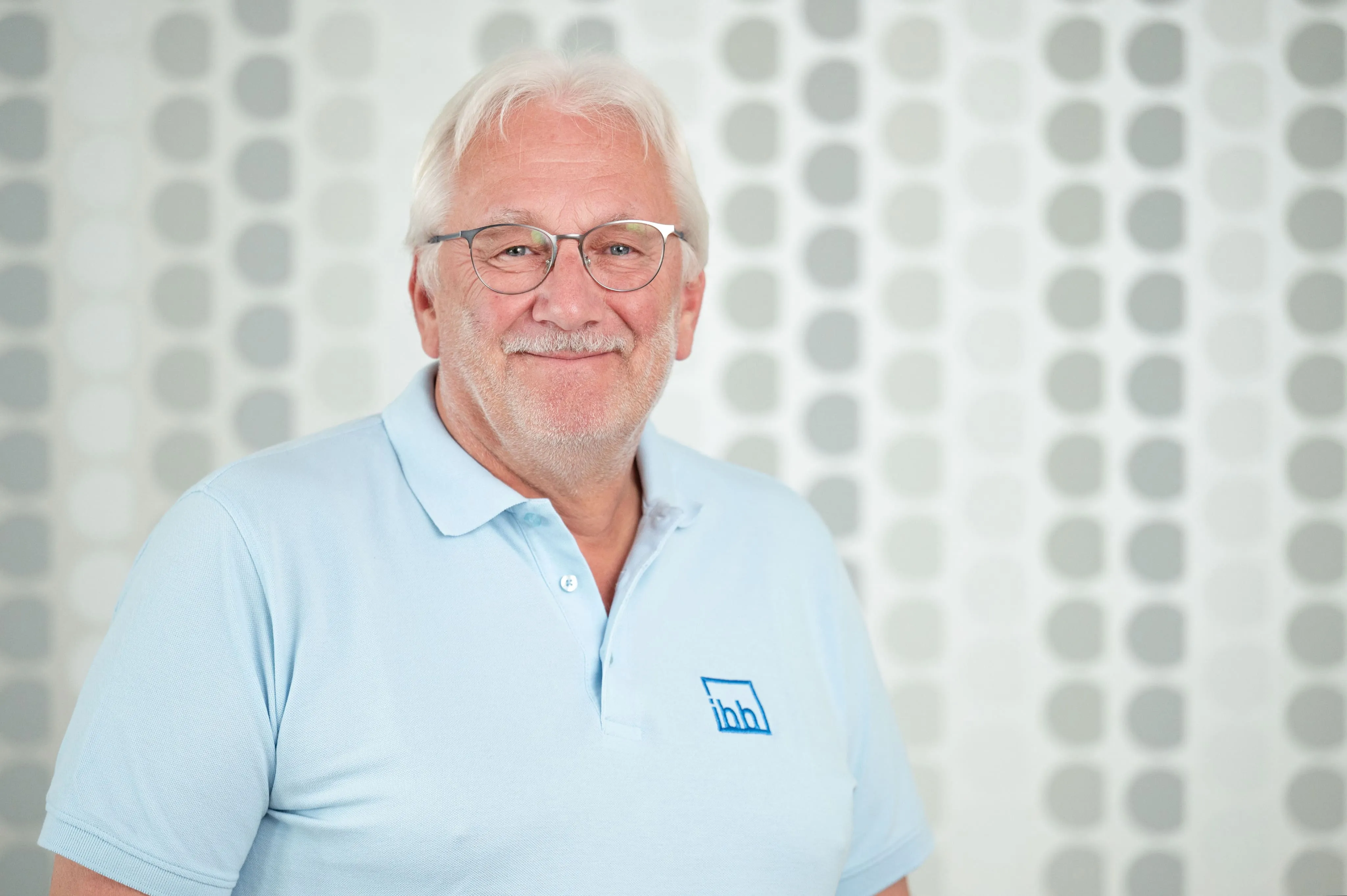 Mitarbeiterporträt eines älteren Mitarbeiters von Ingenieurbüro Bittner im hellblauen Poloshirt