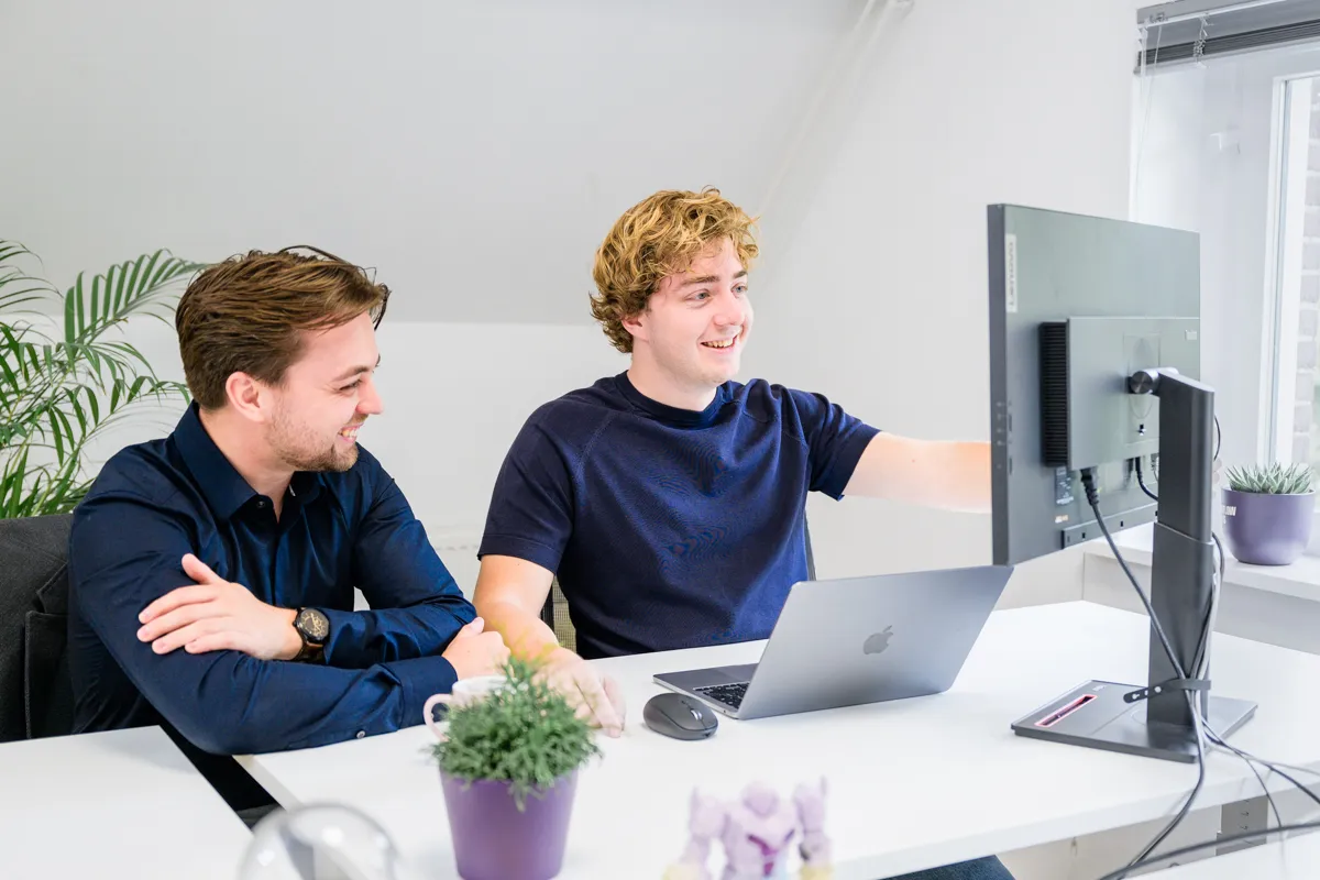 Foto van een werkbespreking tussen Jonas en Tom van Workflow Heroes kijkend naar een scherm
