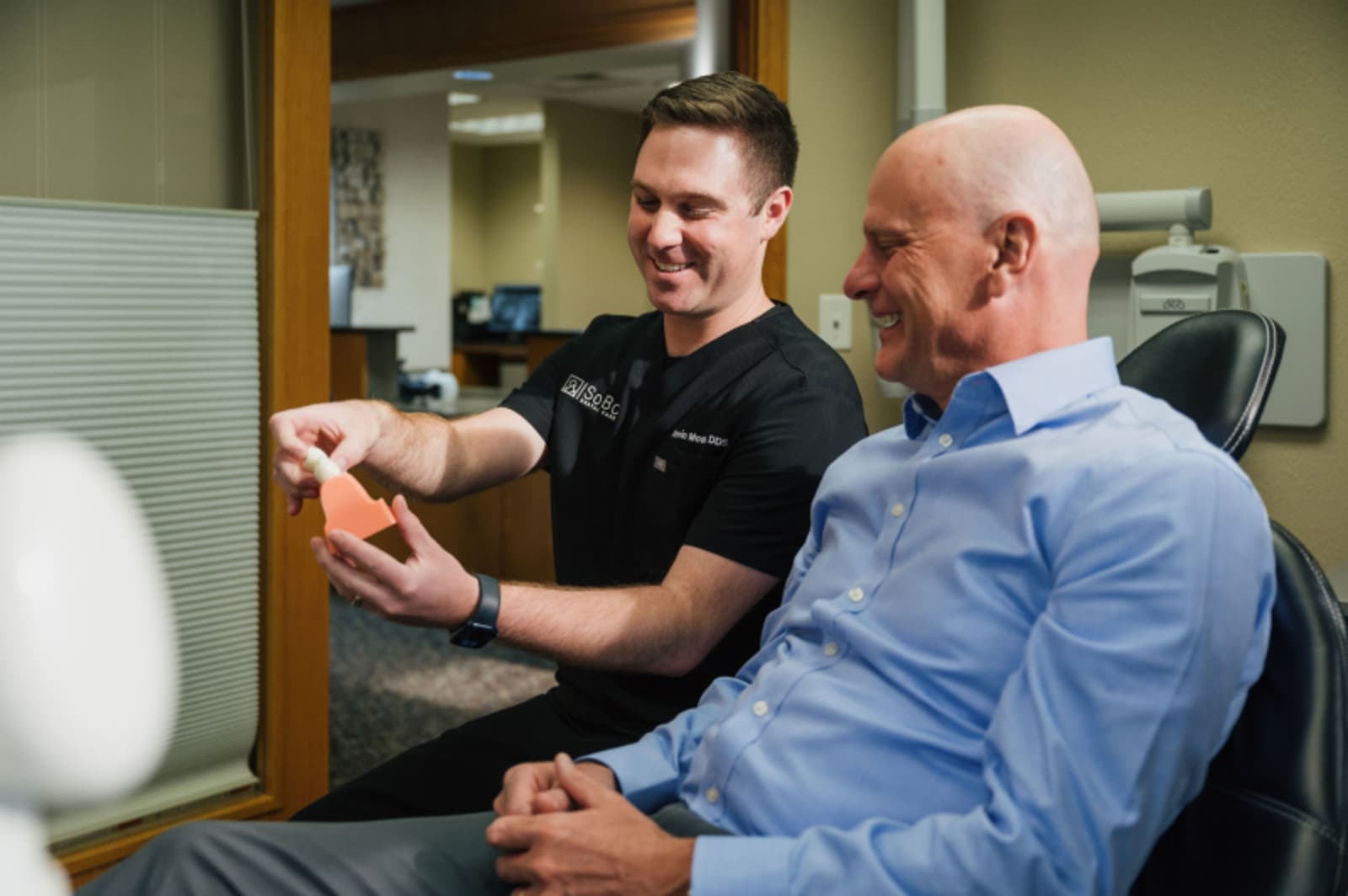 Dr. Kevin Moore discussing dental treatment plan with male patient in treatment room