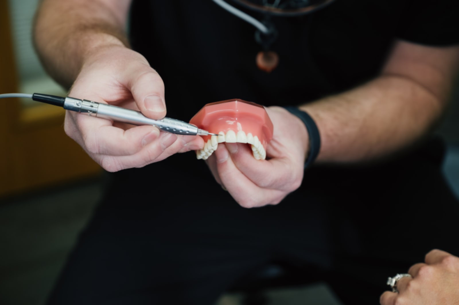 Dentist holding and examining a ceramic crown restoration in hands