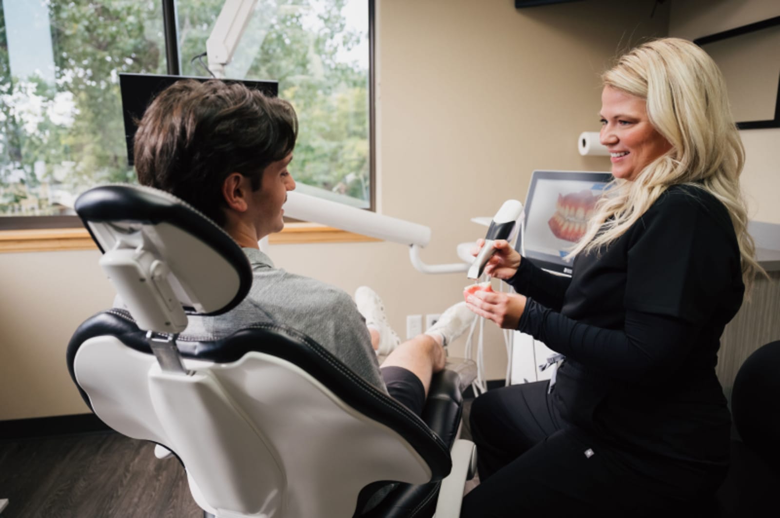 Female dentist smiling during consultation with patient in dental chair