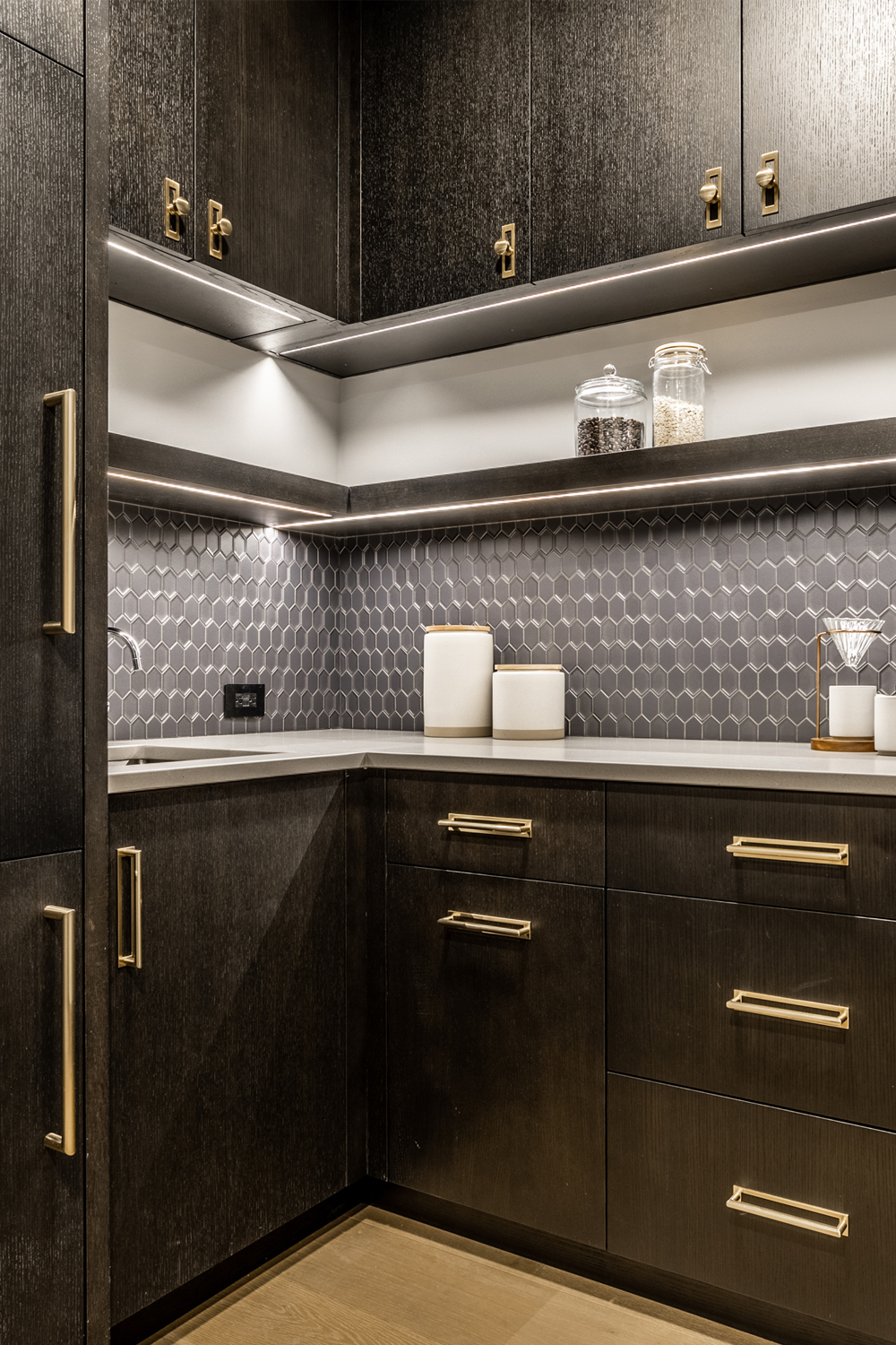 working pantry with dark cabinetry and moody geometric dimensional tile