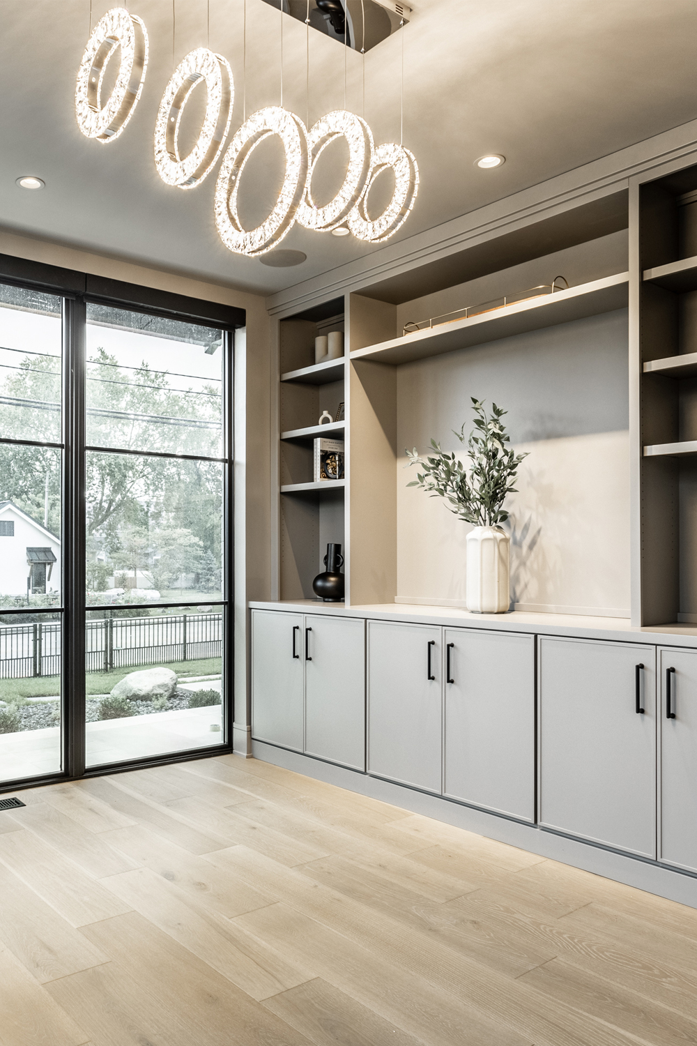 home office in custom home with large window walls and cabinetry built-ins