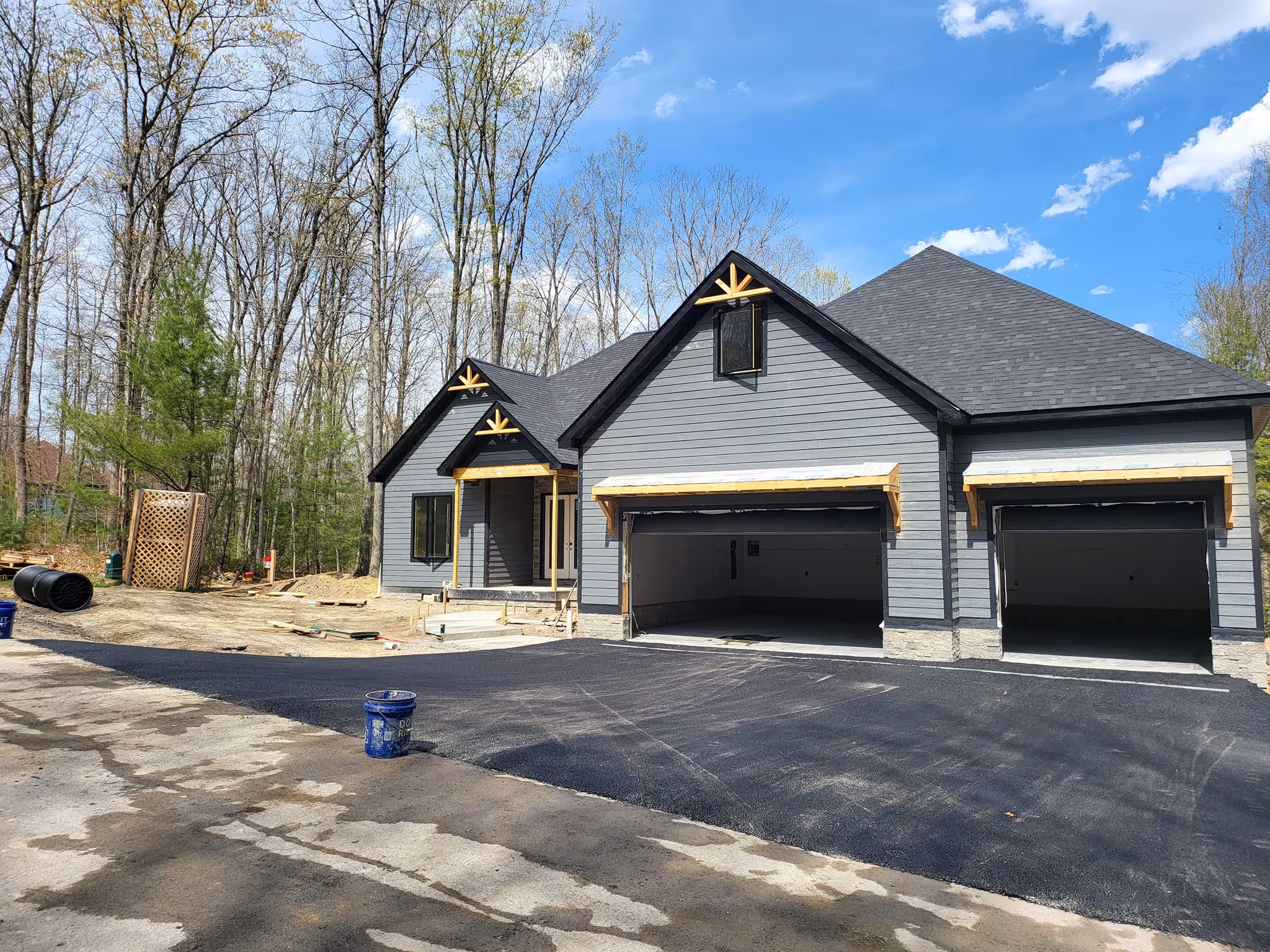 A newly paved driveway in front of a garage.
