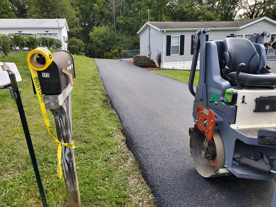 Paving crews actively working out a driveway paving outside of a home.