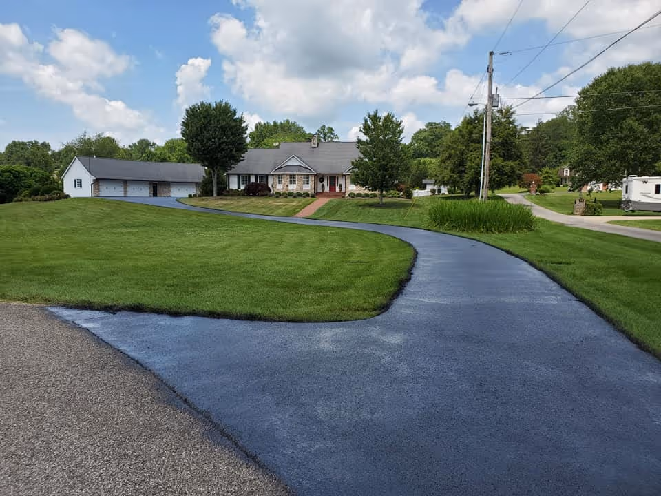 Image of a freshly paved road leading up to a house.