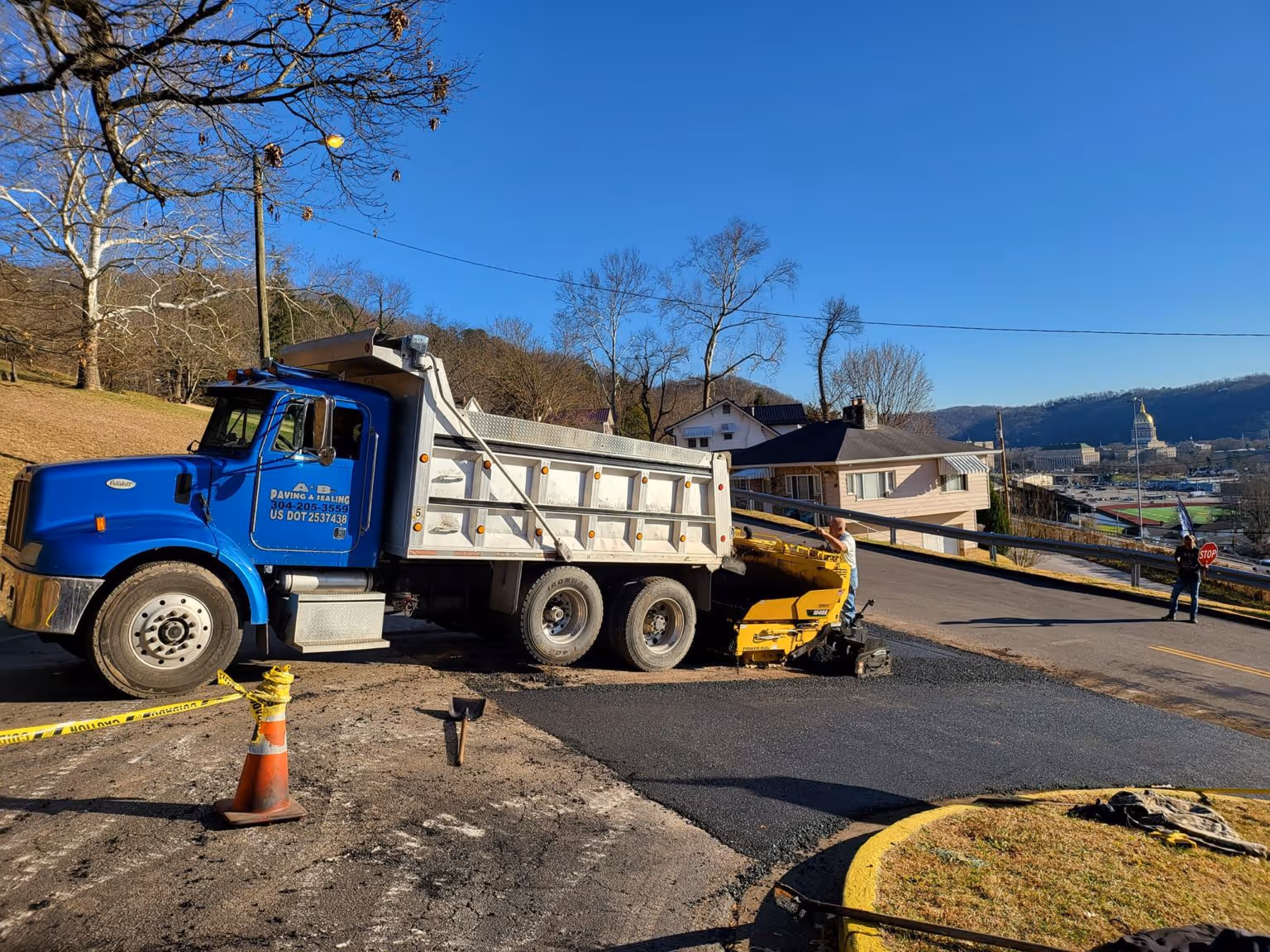 A dump truck actively working on a paving prioject.