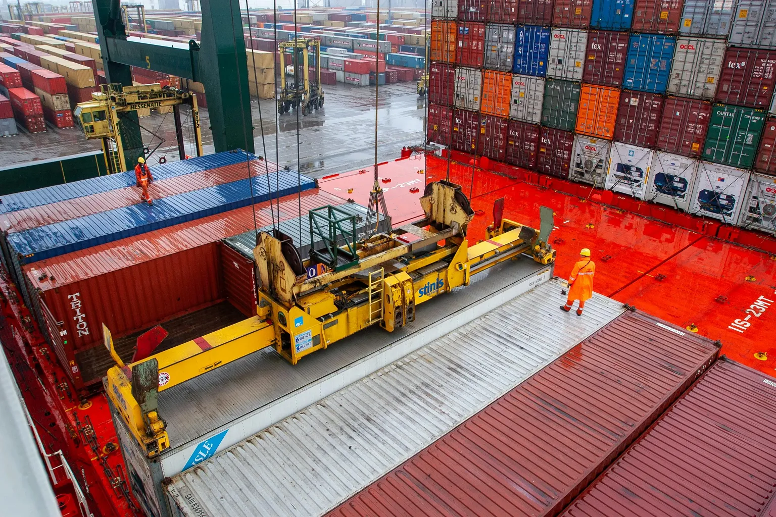 Workers at shipping yard loading industrial freight