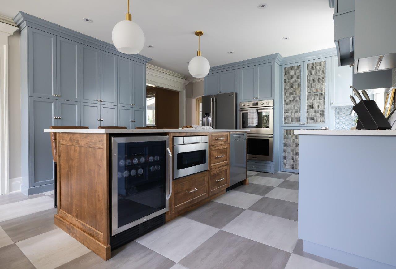 Integrated pop-out stool under the wall oven and next to concealed radiators and slide-out trash compartments.