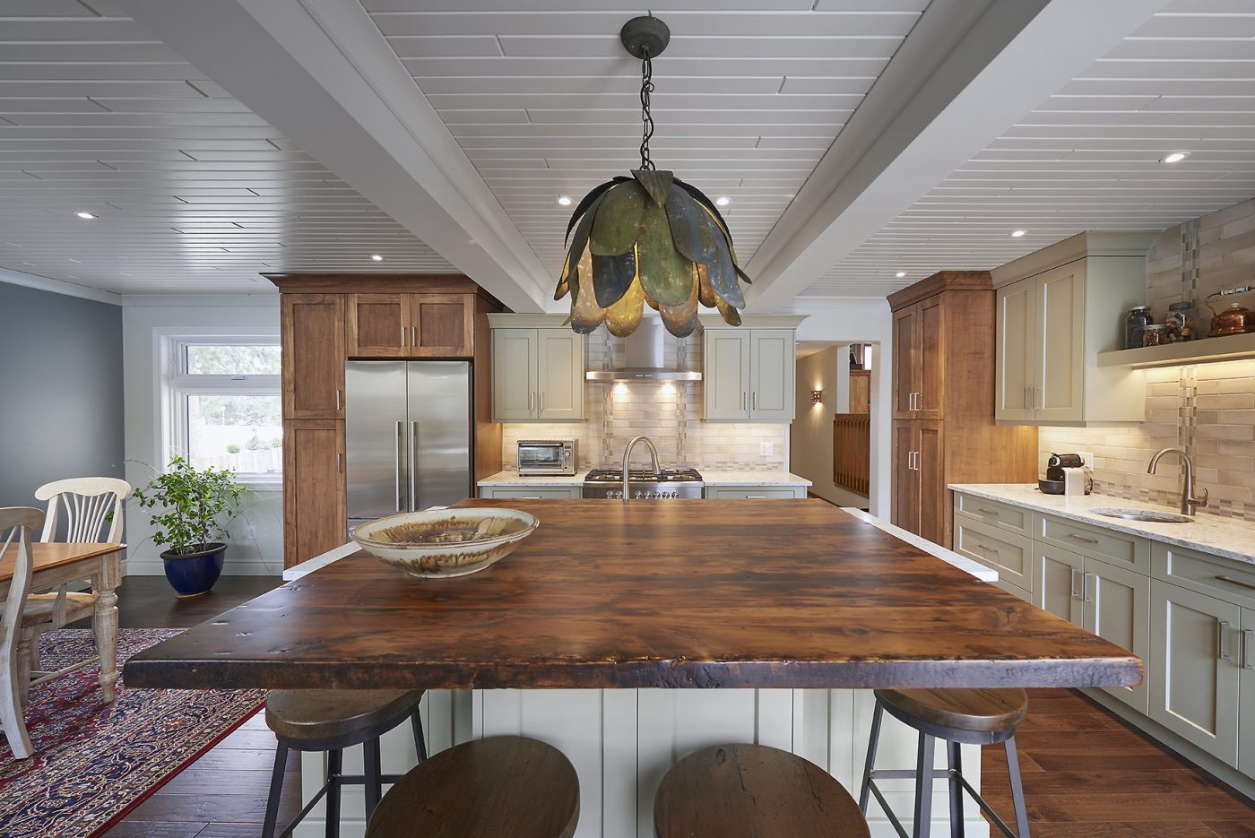 Beautiful wood and beam ceiling and natural wood elements throughout add a dramatic touch to this kitchen