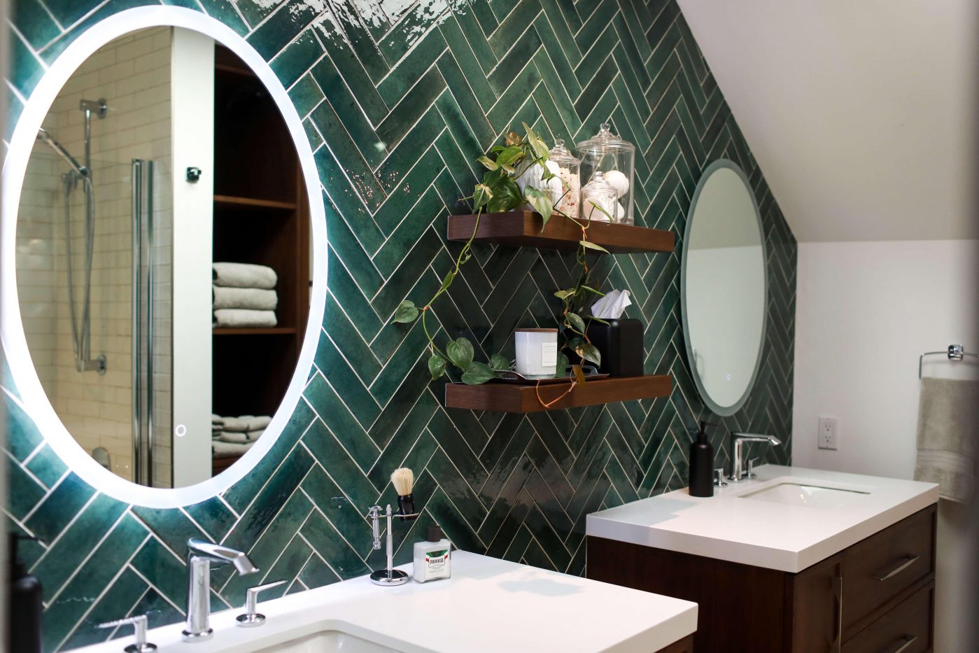 An ensuite bathroom with a stunning tiled feature wall and the floating wooden vanities.