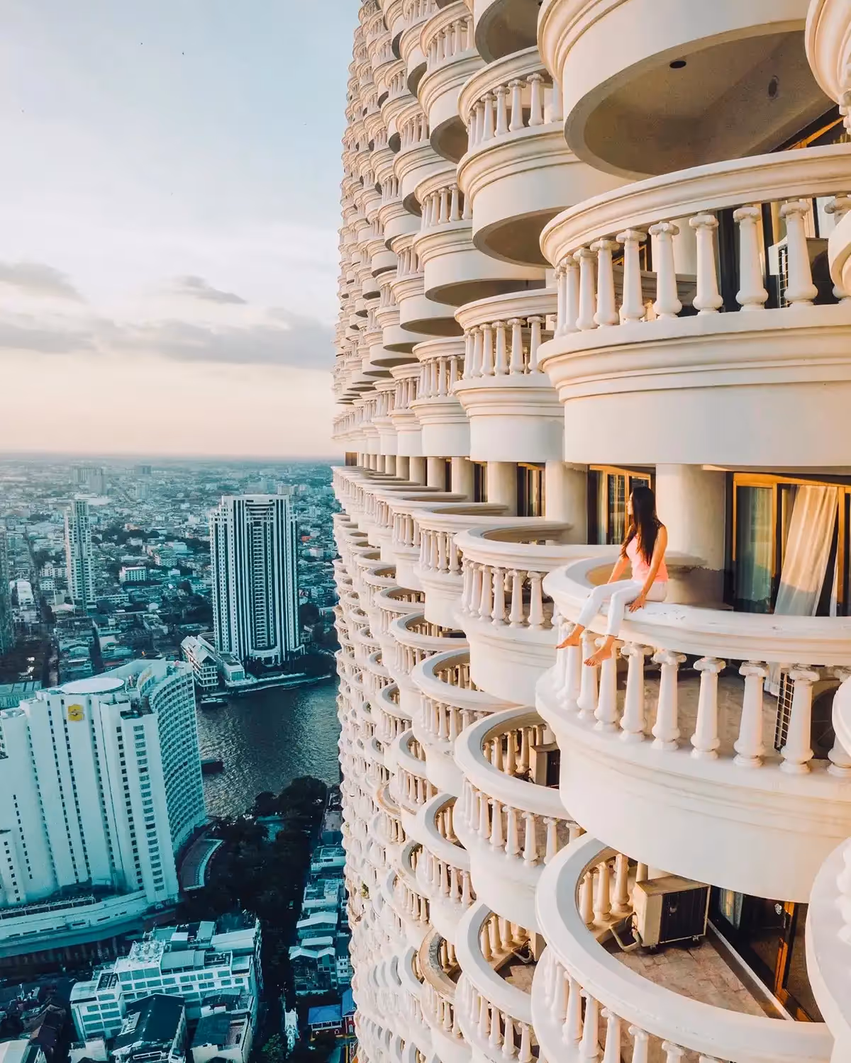 An image of Catherine Tang looking out over a balcony of a tall building.