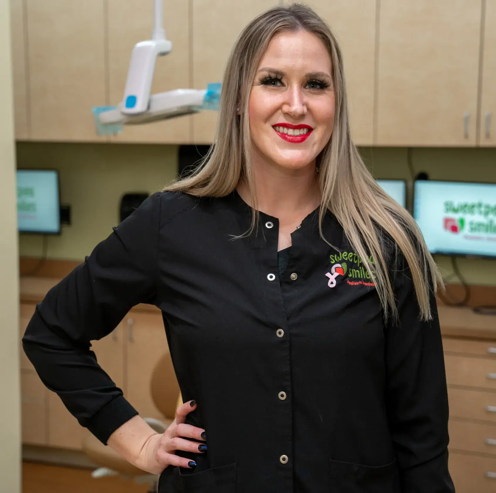 a woman standing in a dental office with her hands on her hips