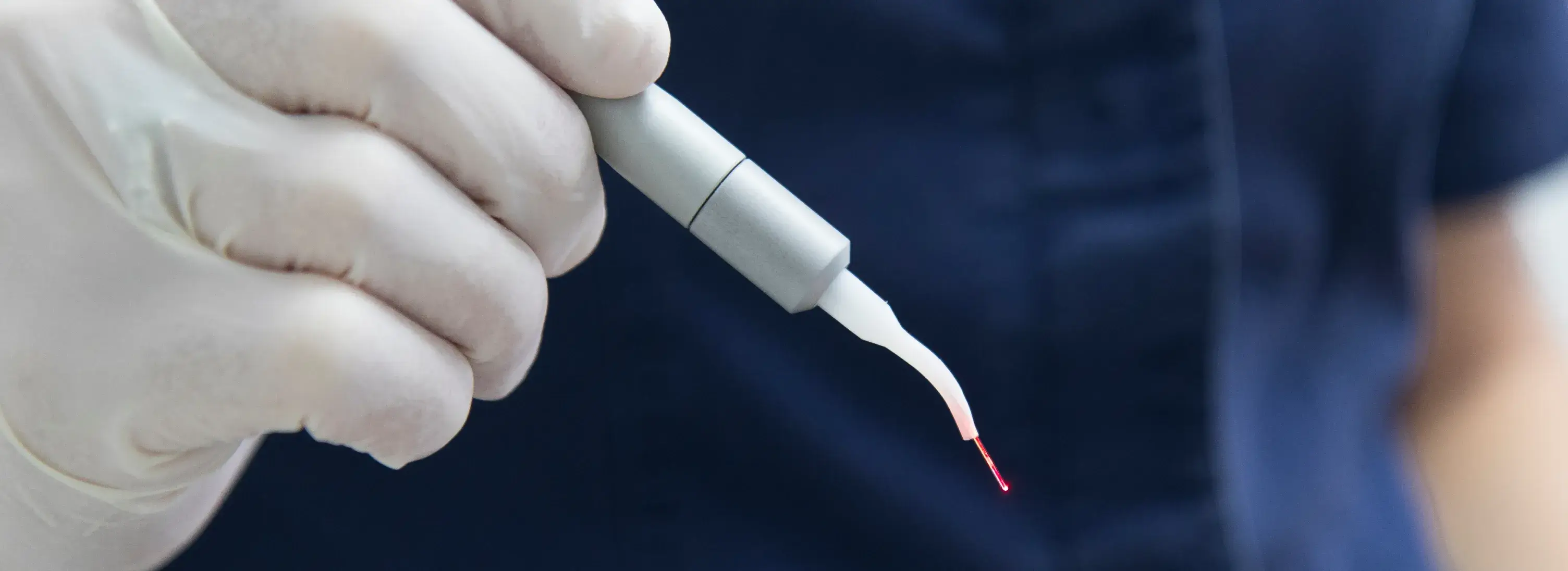 a person in white gloves holding a medical device