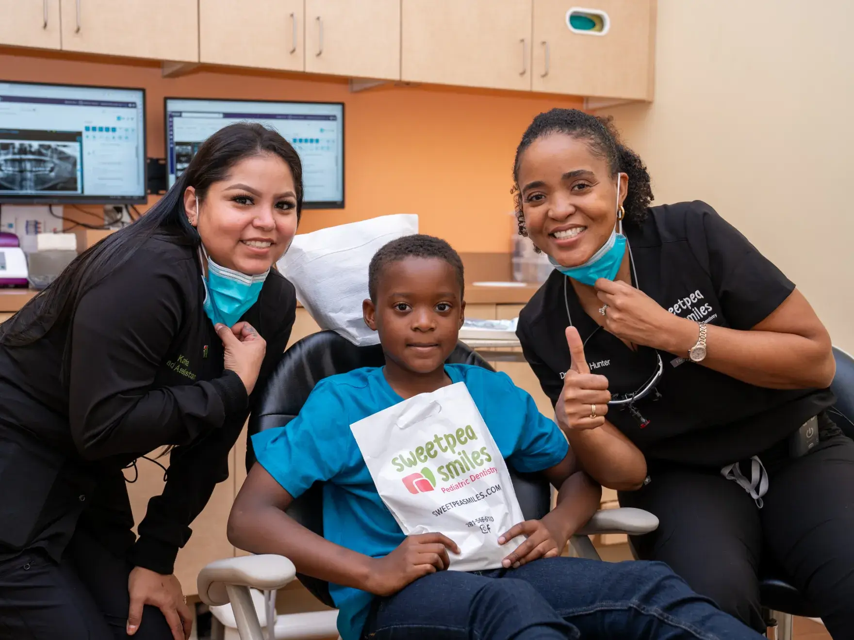 a woman and two children in a dental office