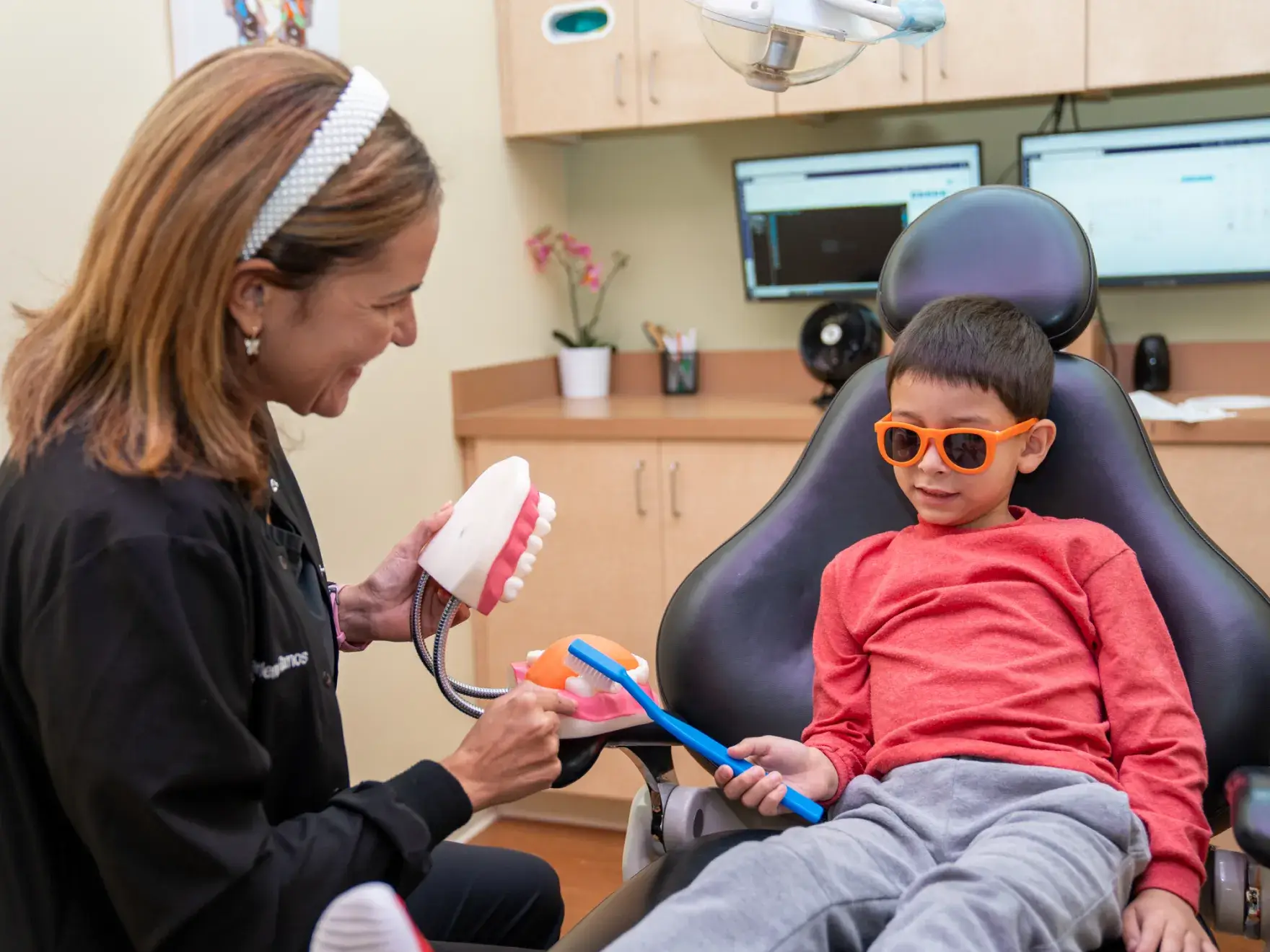a young boy getting his teeth brushed by a dentist