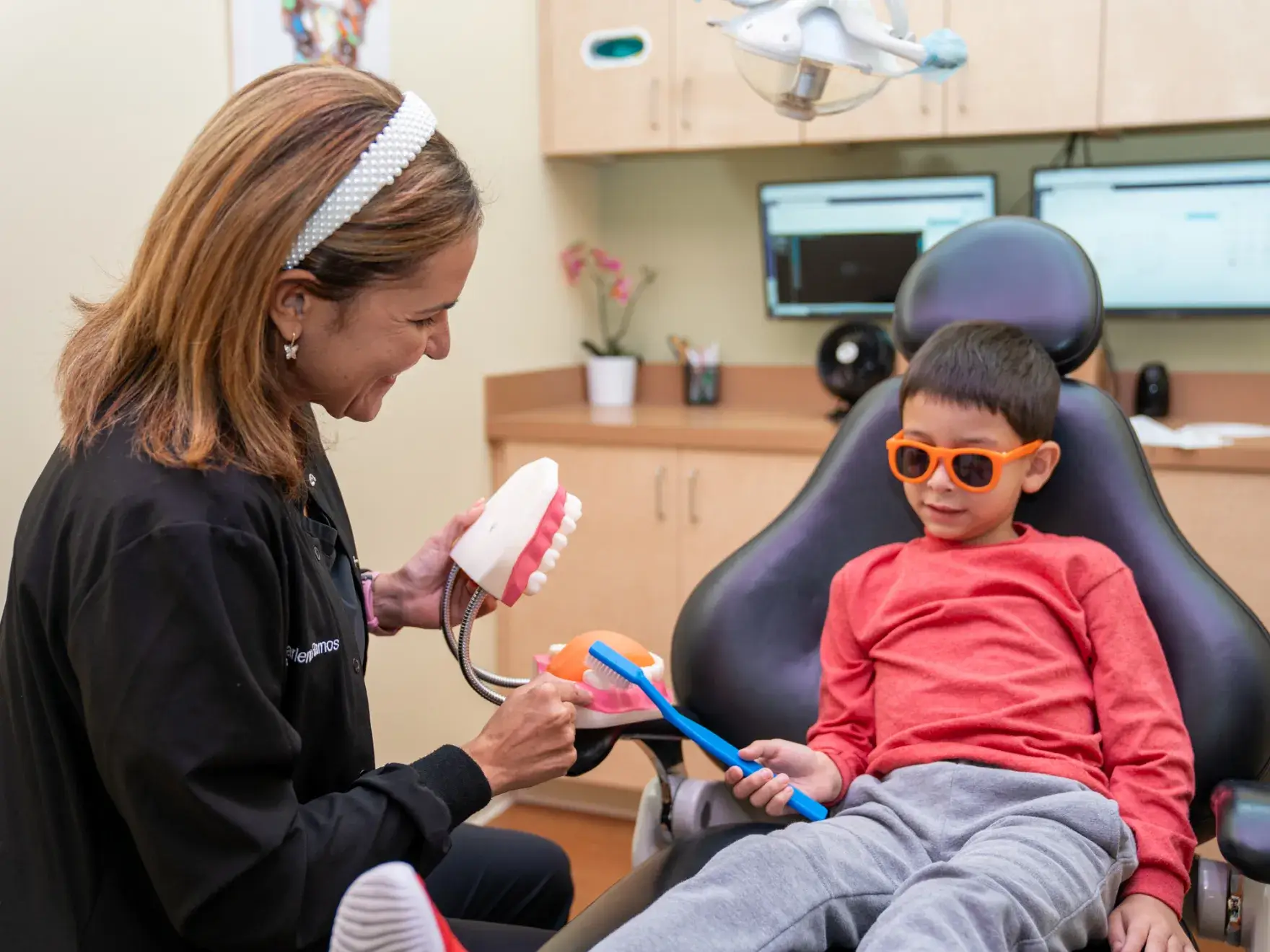 a young boy getting his teeth brushed by a dentist