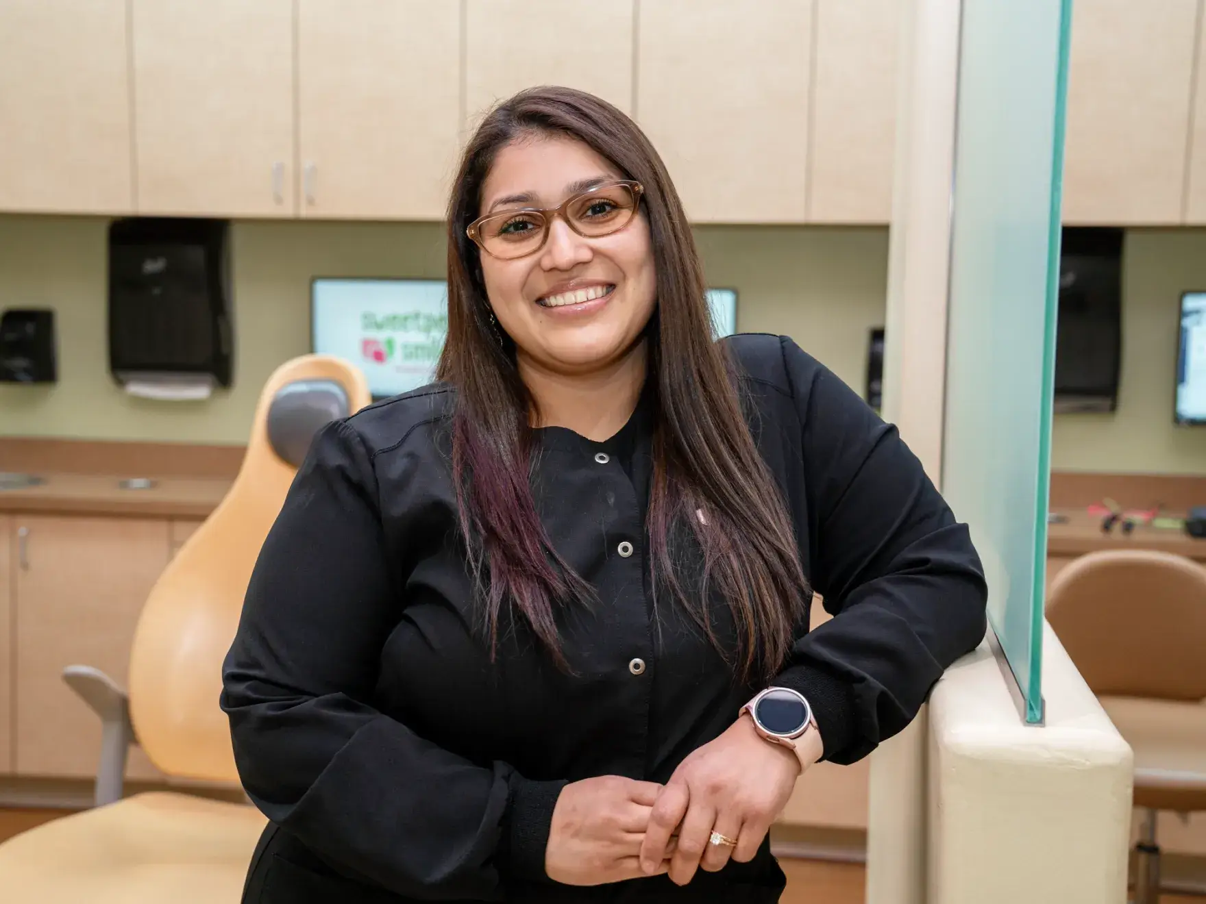 a woman standing in a dental office with a watch on her wrist