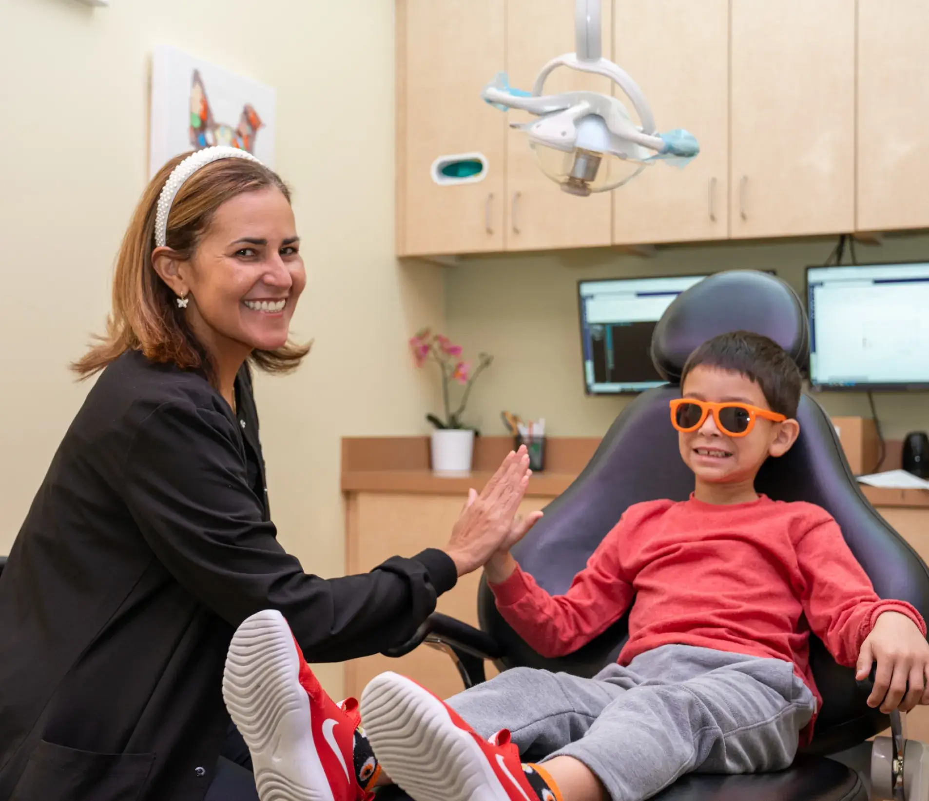 a woman sitting next to a boy in a dental chair