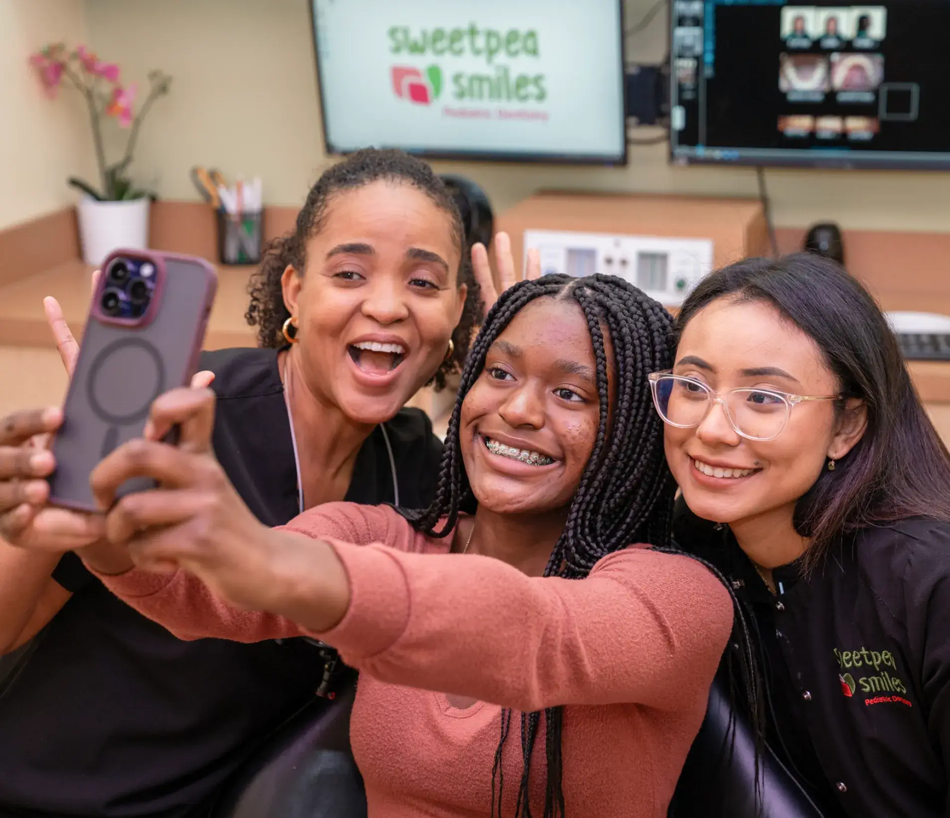three women taking a selfie with a cell phone