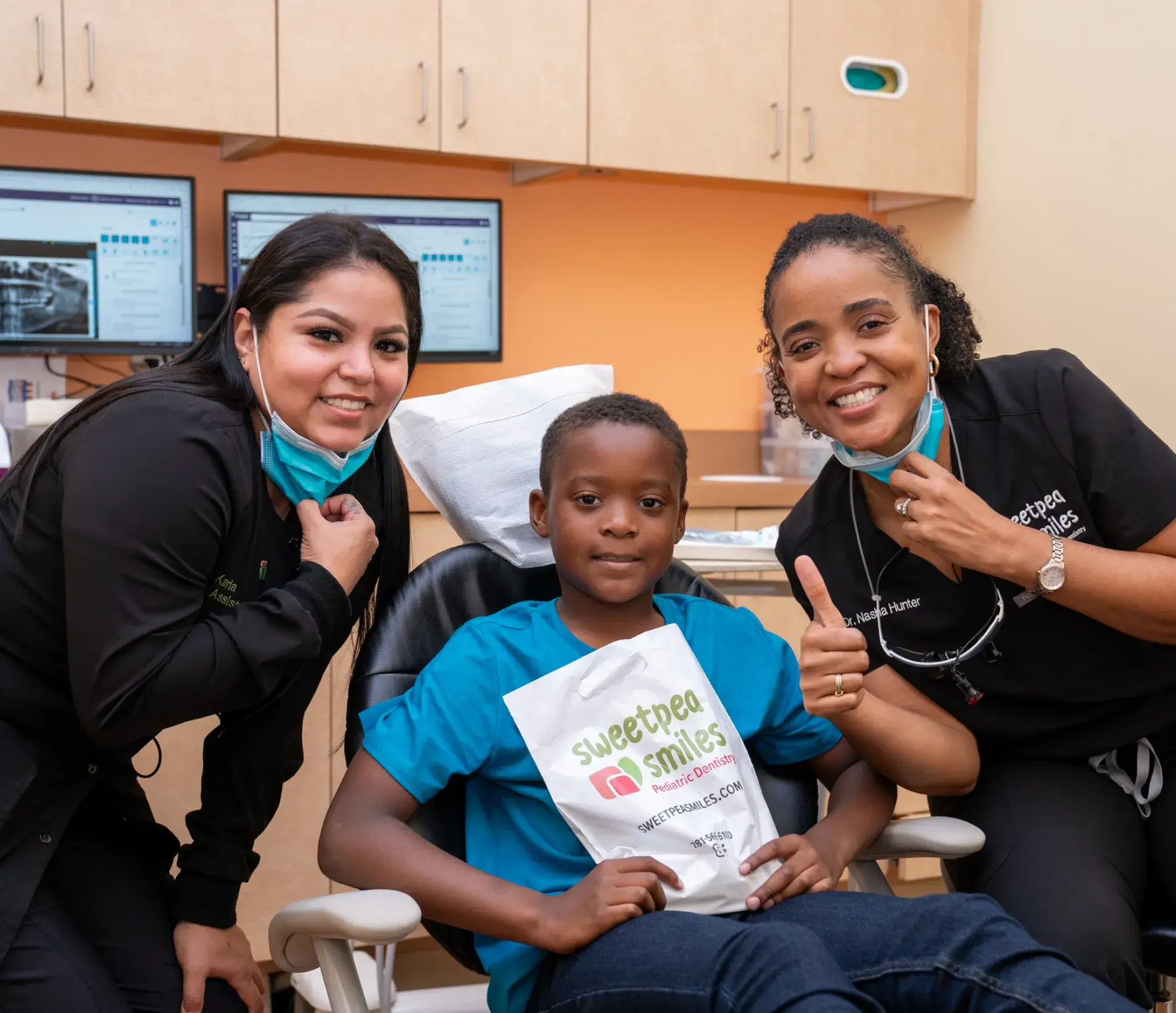 three women and a boy in a dental office