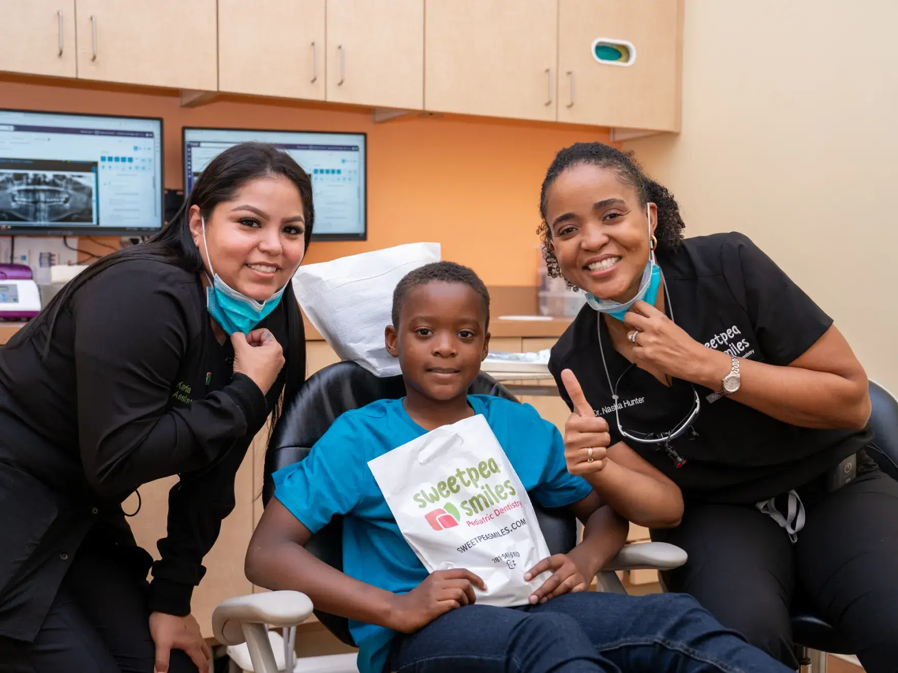 three women and a boy in a dental office