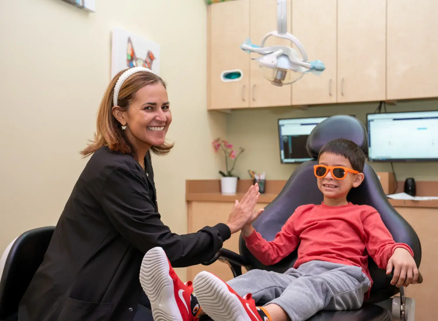 a woman sitting next to a boy in a dentist chair