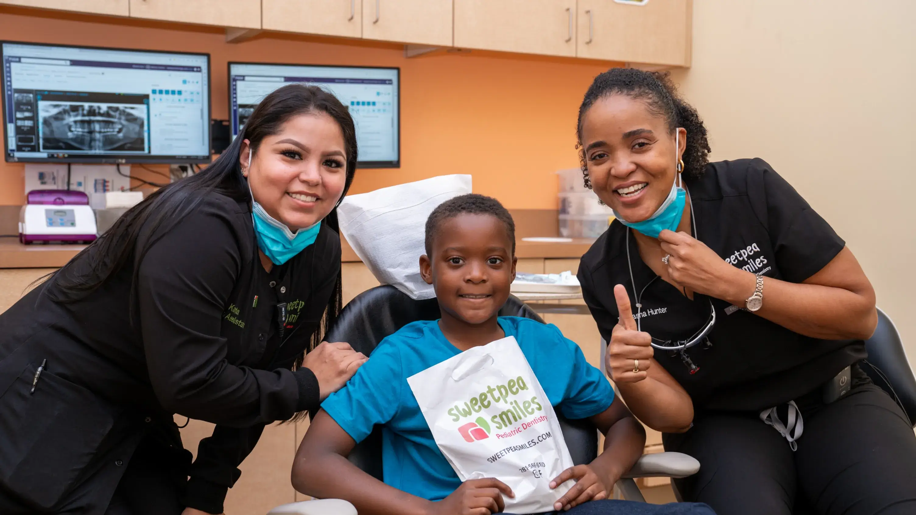 a woman and two children in a dental office