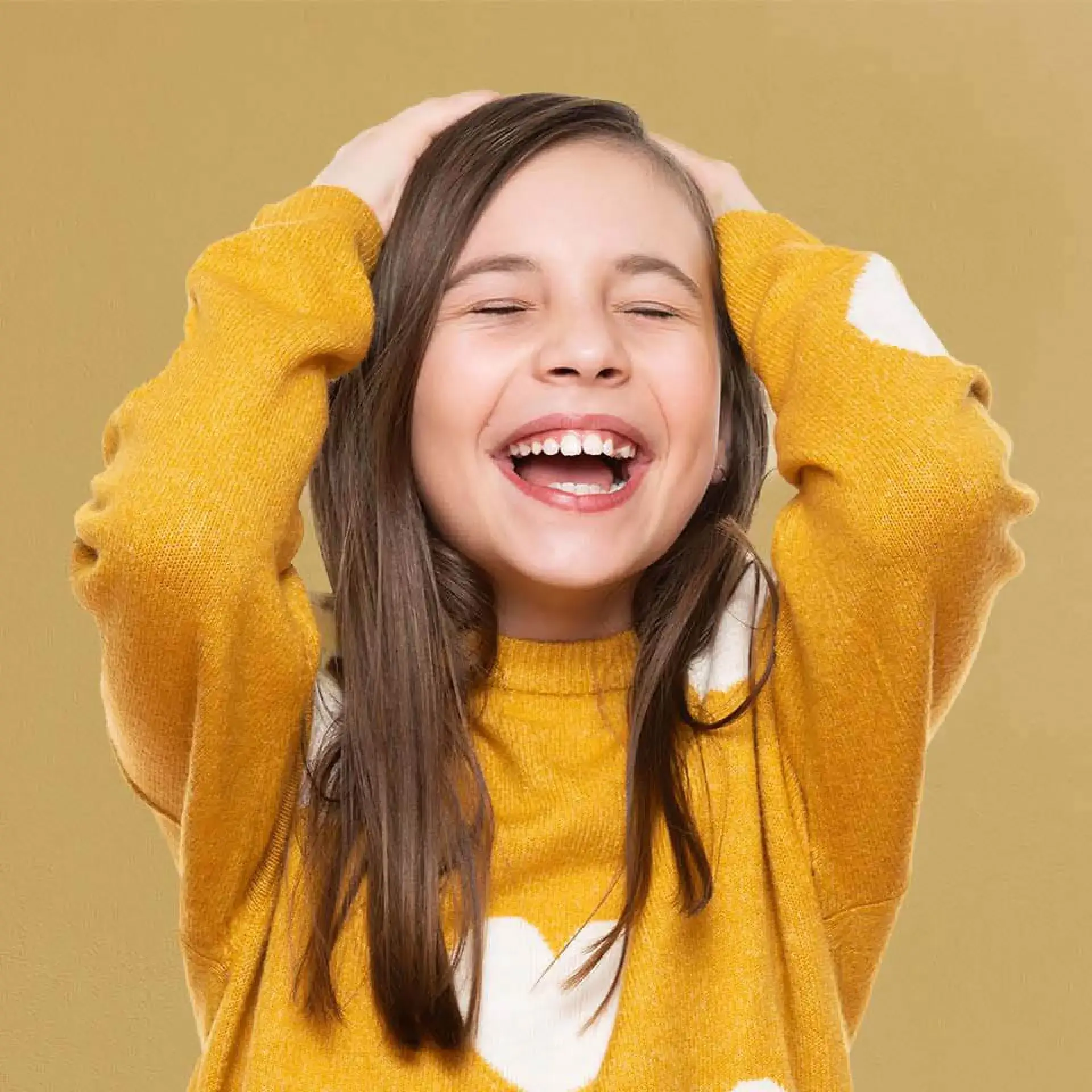 a young girl is smiling and holding her head
