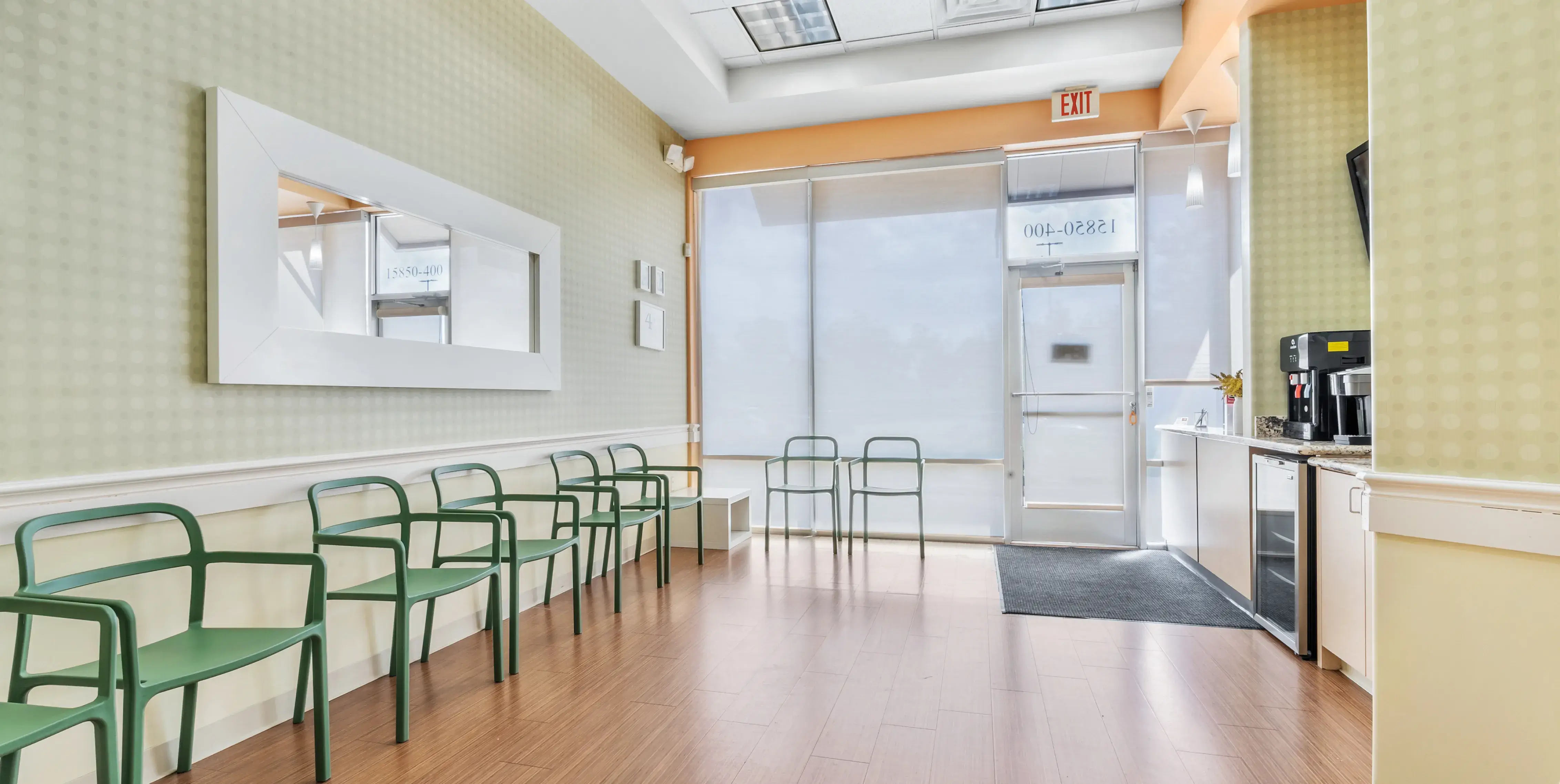 a row of green chairs sitting in a room