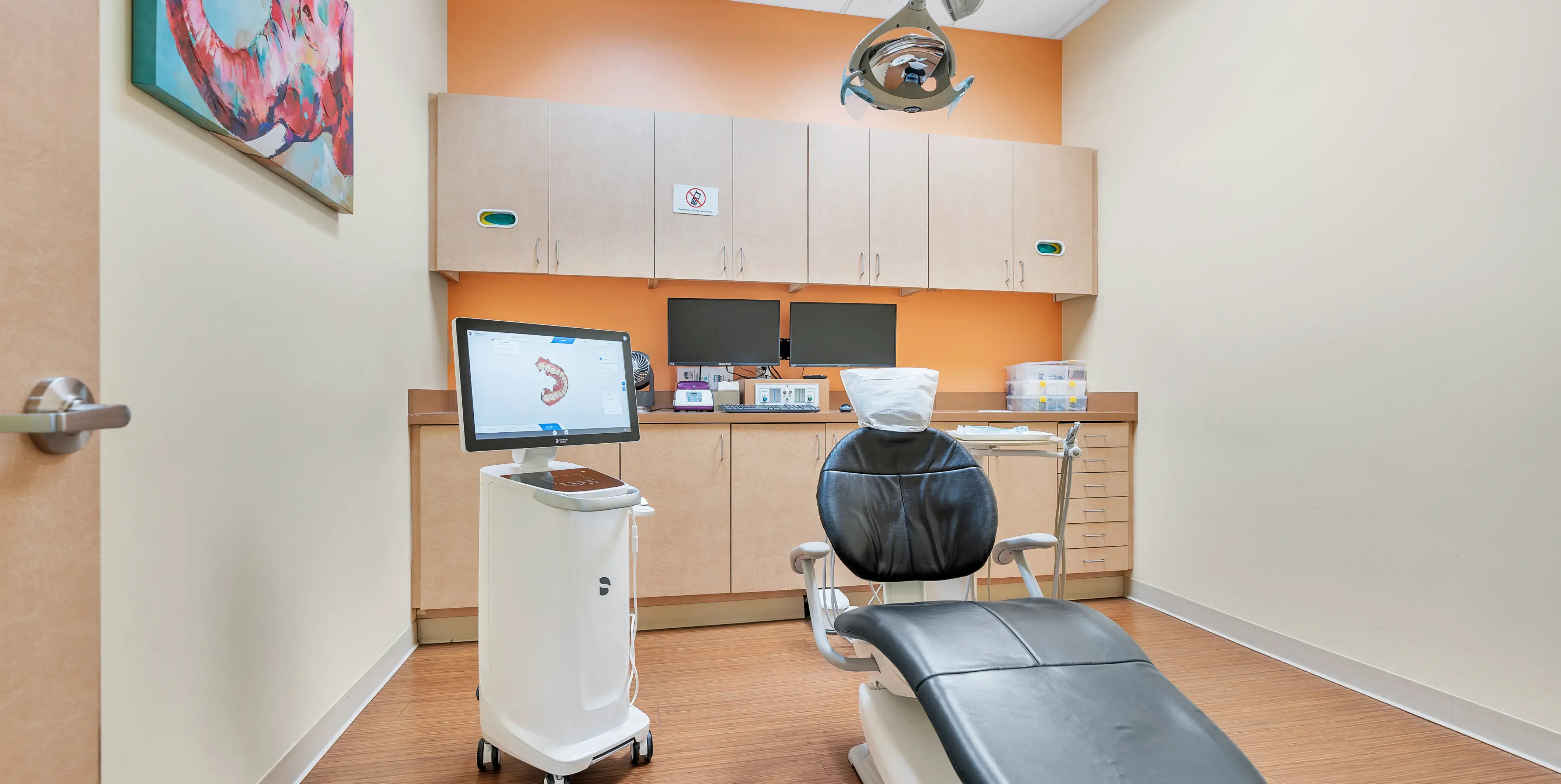 a dentist's office with a chair and a monitor