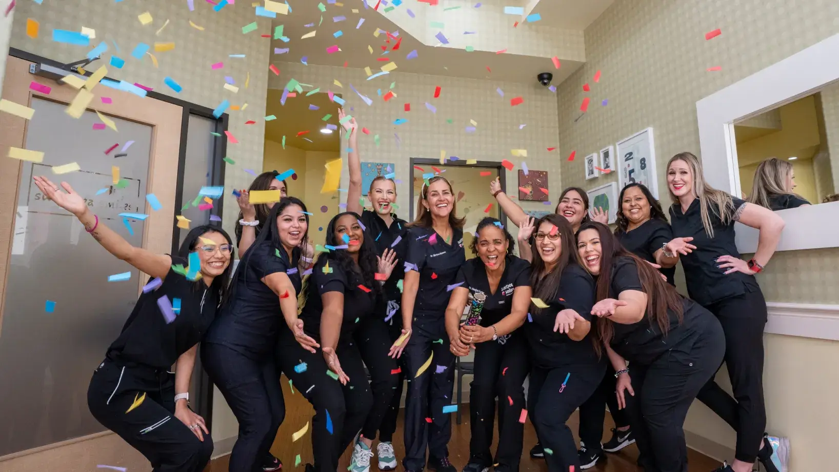 a group of women standing next to each other under confetti
