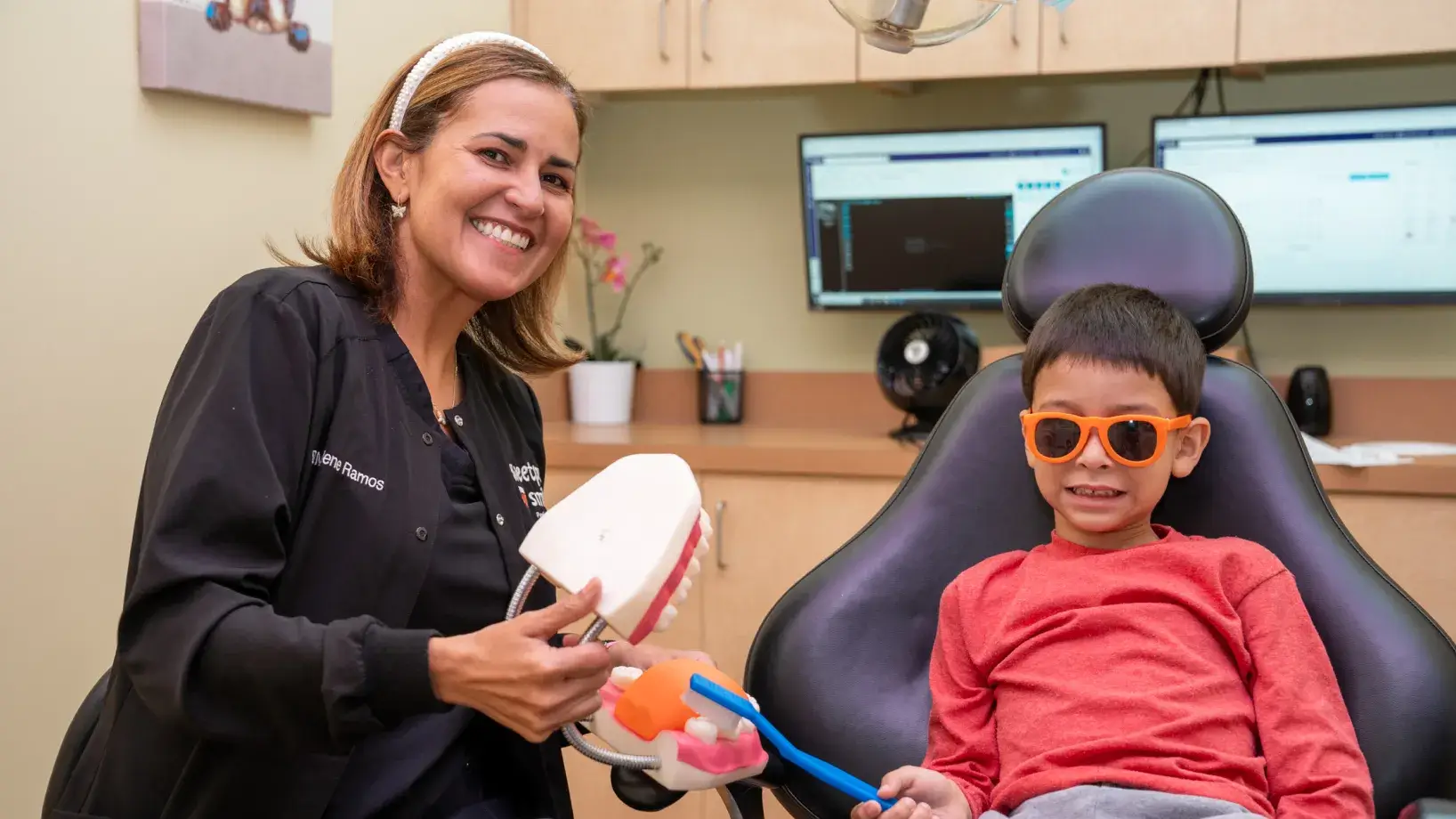 a woman and a boy sitting in a dentist chair