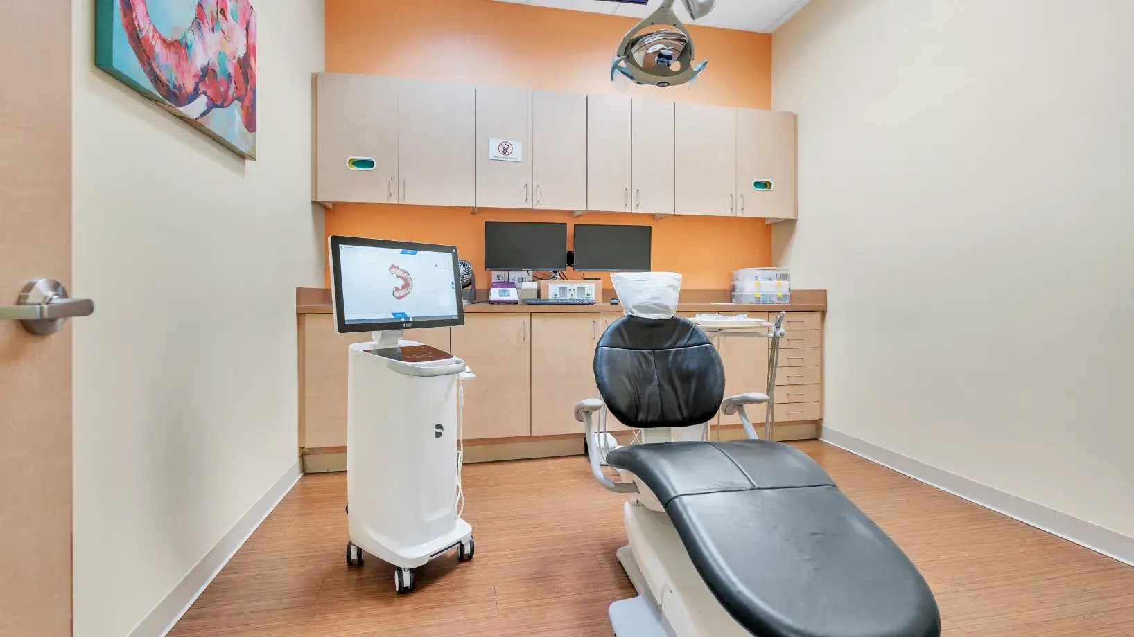 a dentist's office with a chair and a monitor
