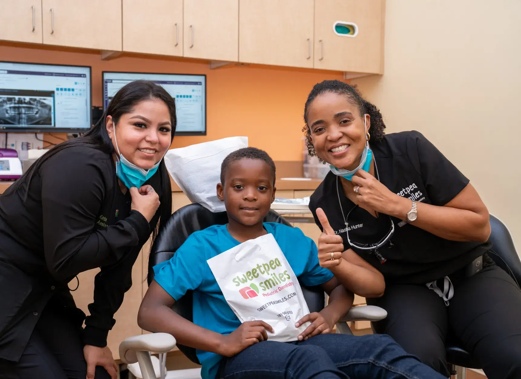 a woman and two children in a dental office