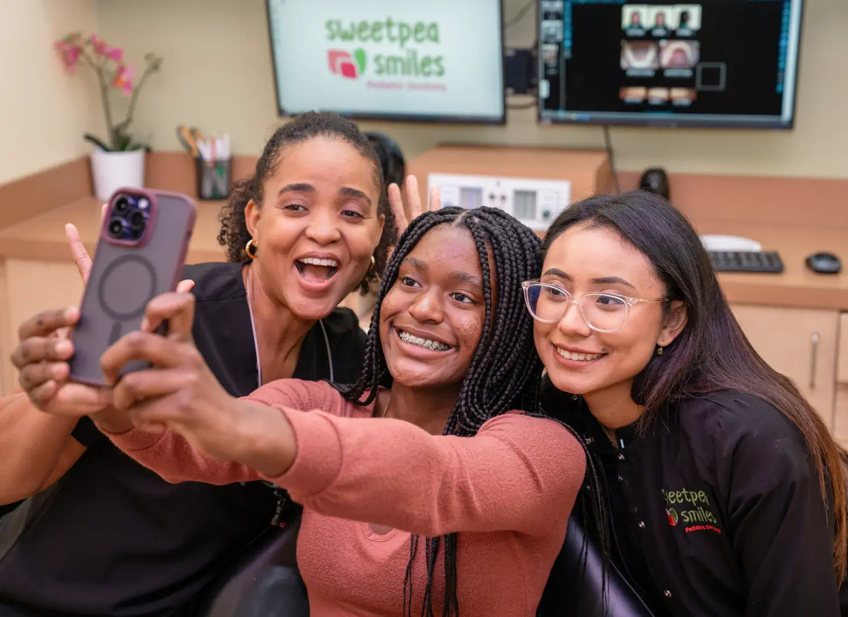 a group of women taking a picture with a cell phone