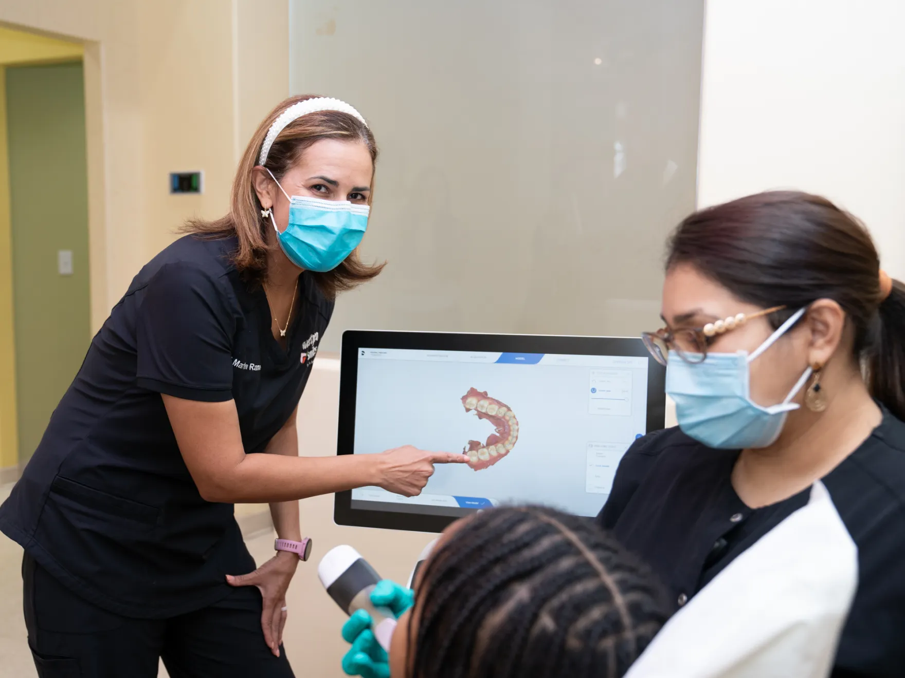 a group of women in scrubs and masks looking at a computer screen