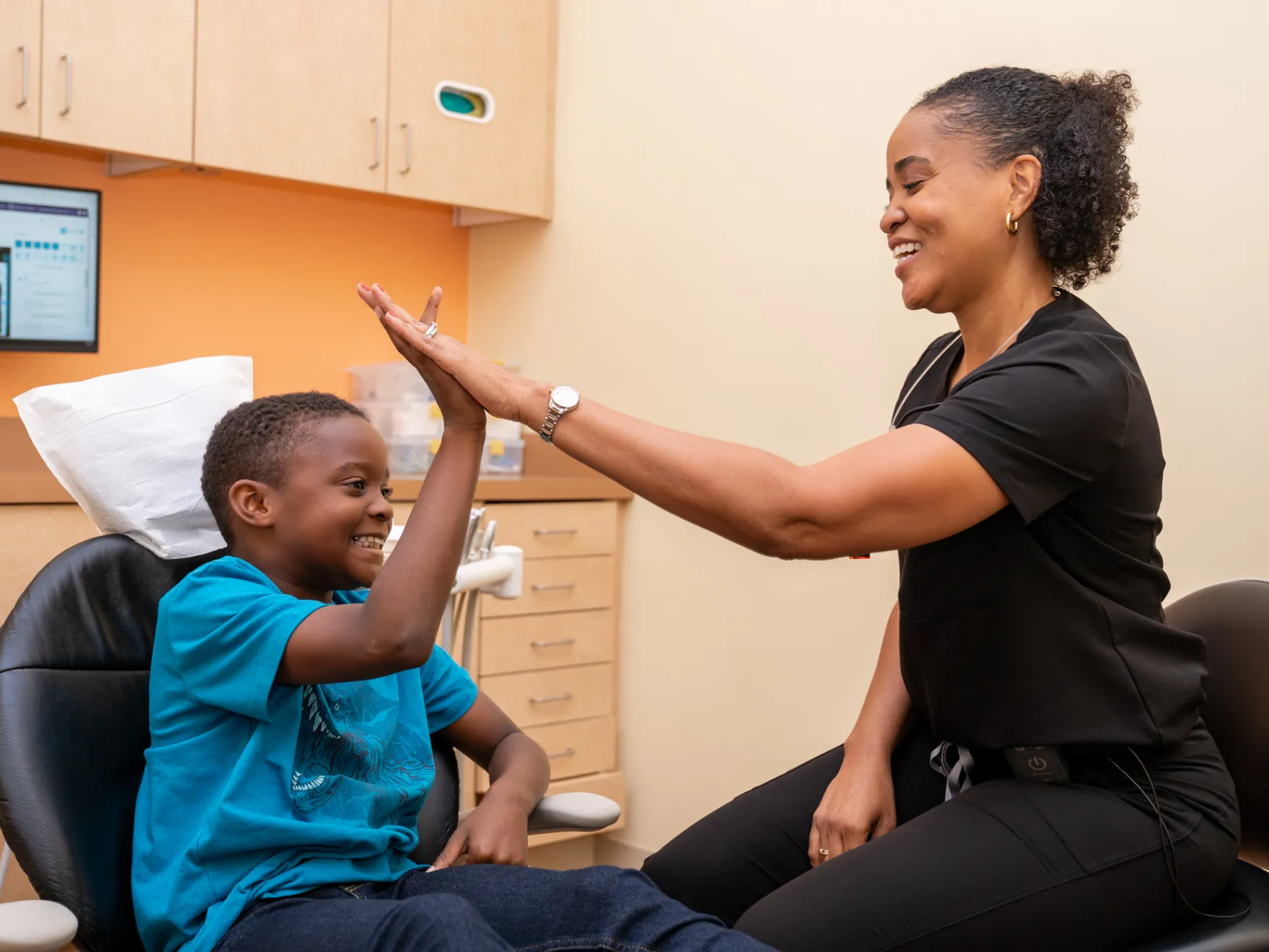 a woman is giving a boy a high five