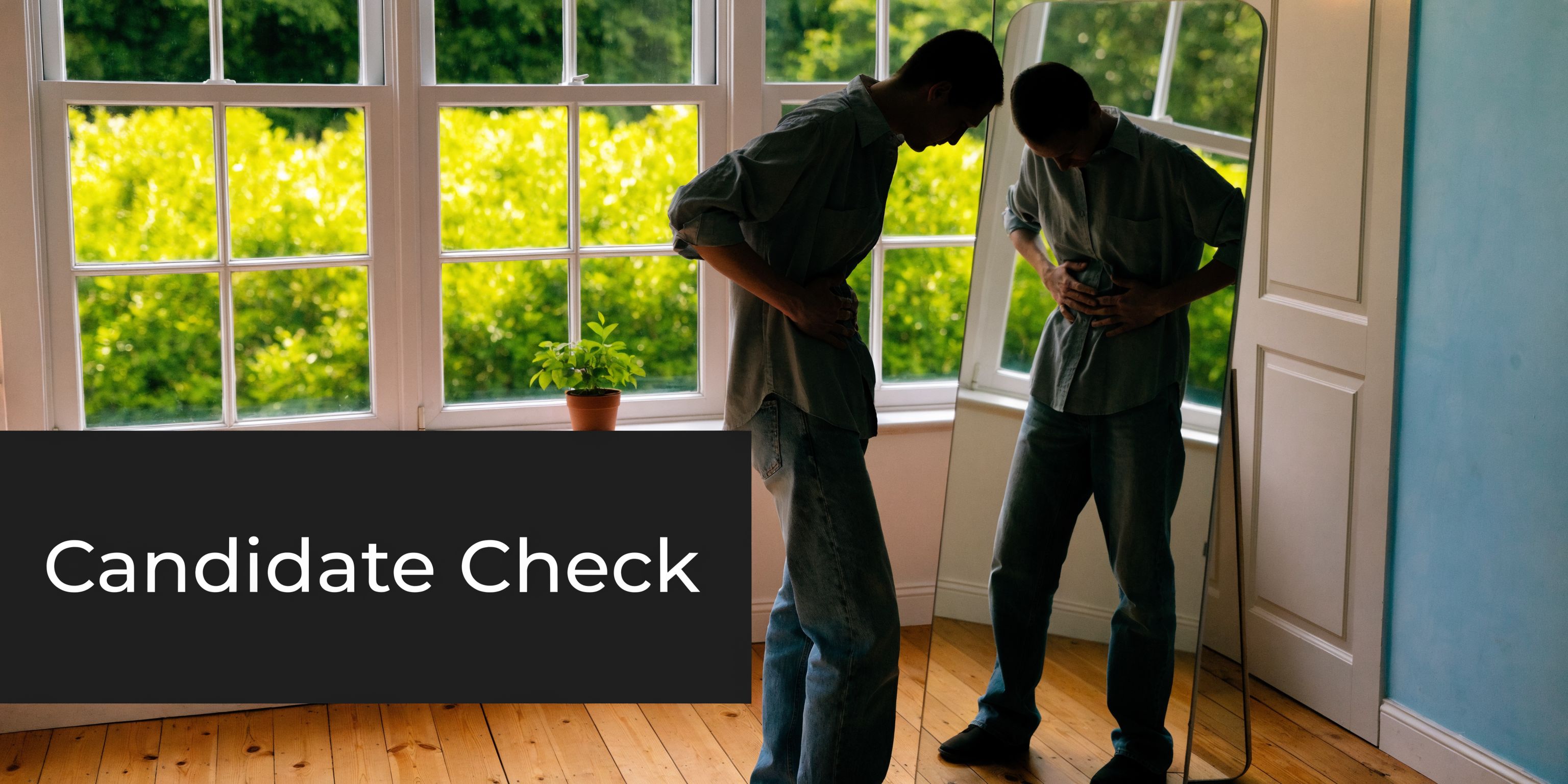 A person standing in front of a mirror while holding their stomach area, assessing abdominal skin appearance.