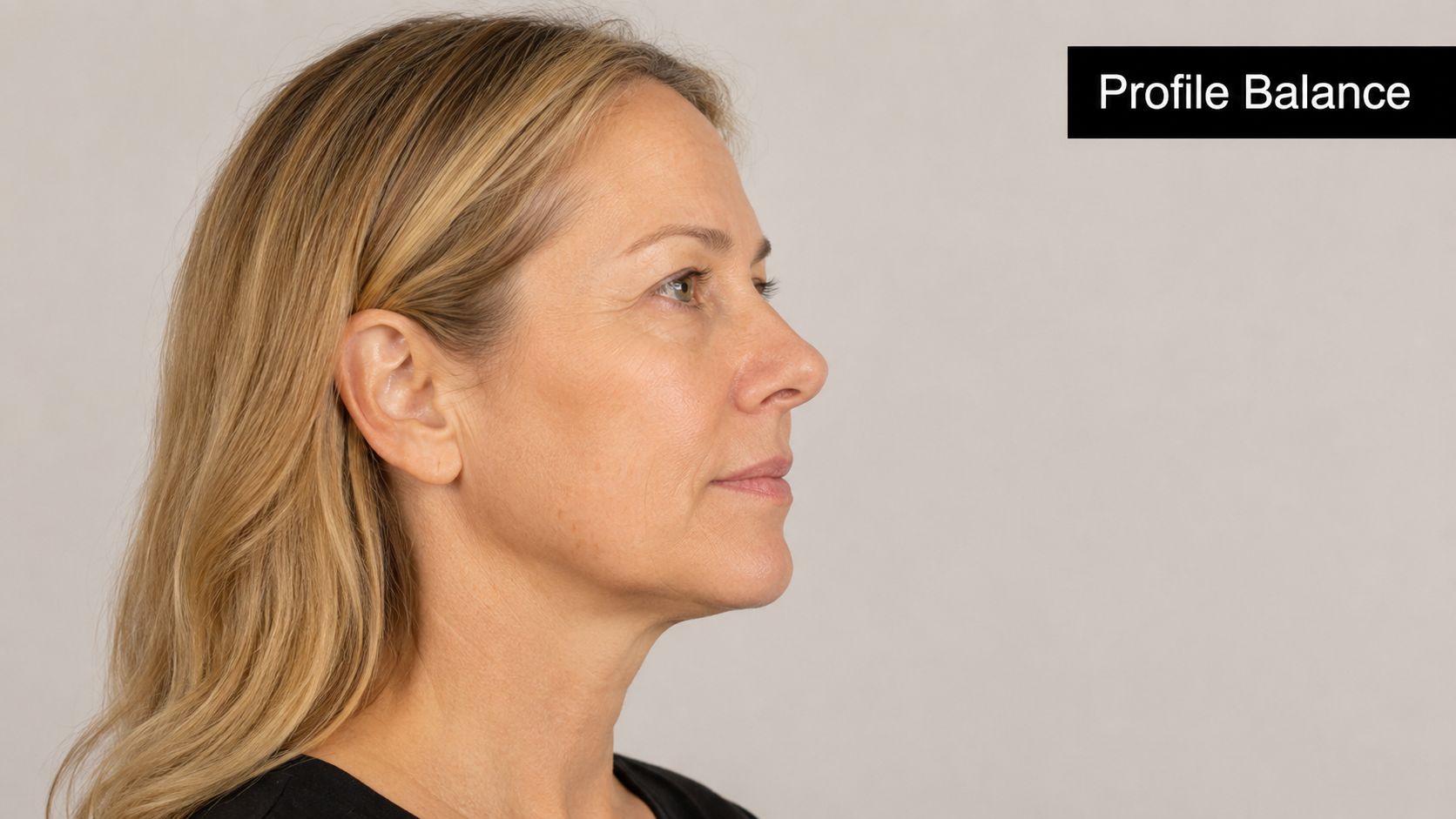 A side profile view of a woman showing natural skin texture, jawline contour, and facial appearance.