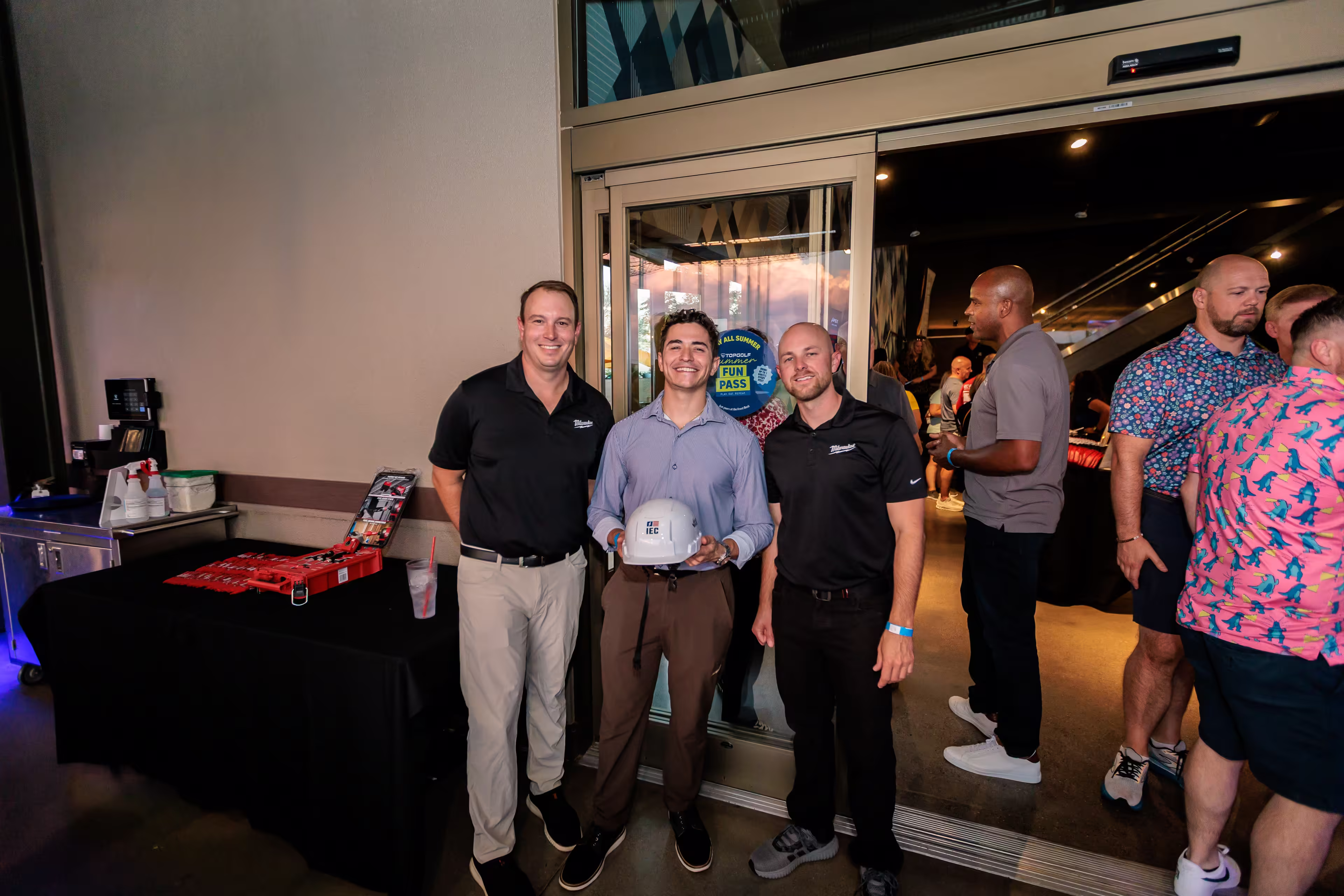Men posing for photo in IEC Foundation shirts at Top Golf Arizona event