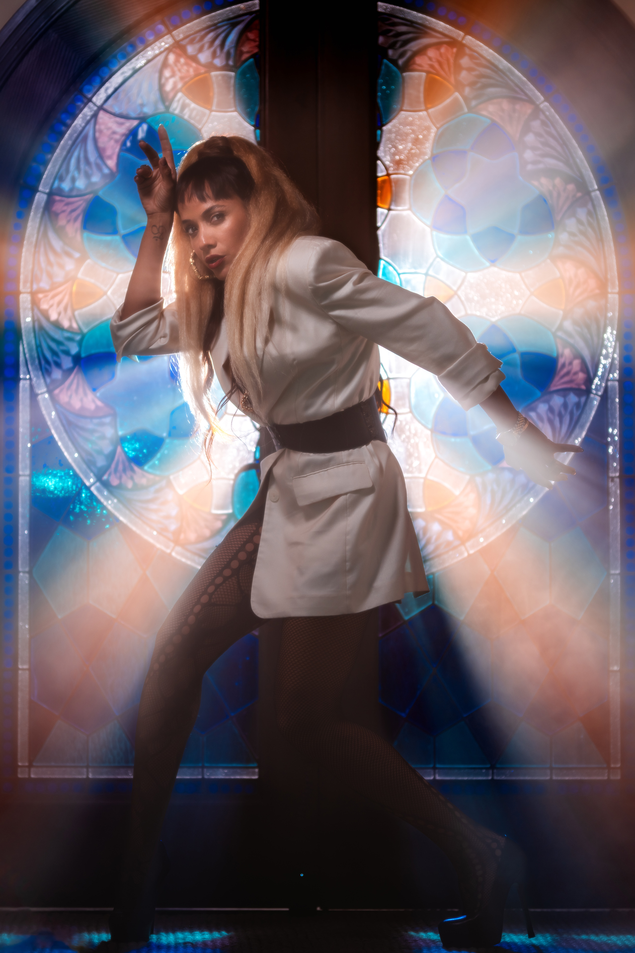 Dania Ramirez posing in white outfit with stained glass backdrop in cinematic fashion shoot